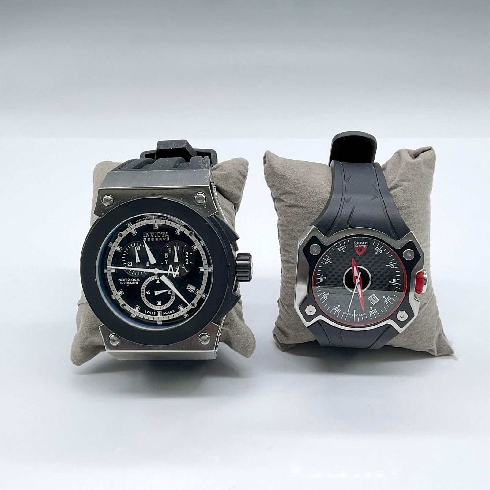 2pc Invicta and Ducati Men's Watches, Black Wristbands: Two men's sport watches. Swiss-made Ducati Corse watch with silvertone housing, black face, red hands, black rubber/resin wristband; 10"L x 2"W x 0.5"H. Invicta Reserve Swiss-made thick black and silv