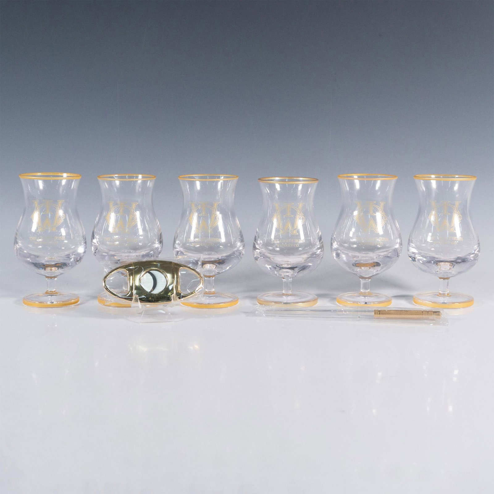8pc The Craft Irish Whiskey Co. Finn Glass Set: This distinguished collection by The Craft Irish Whiskey Co. proudly showcases their logo and includes 6 Finn whiskey tasting glasses, an elegant pipette, and a sleek cigar cutter, ensuring an elevate