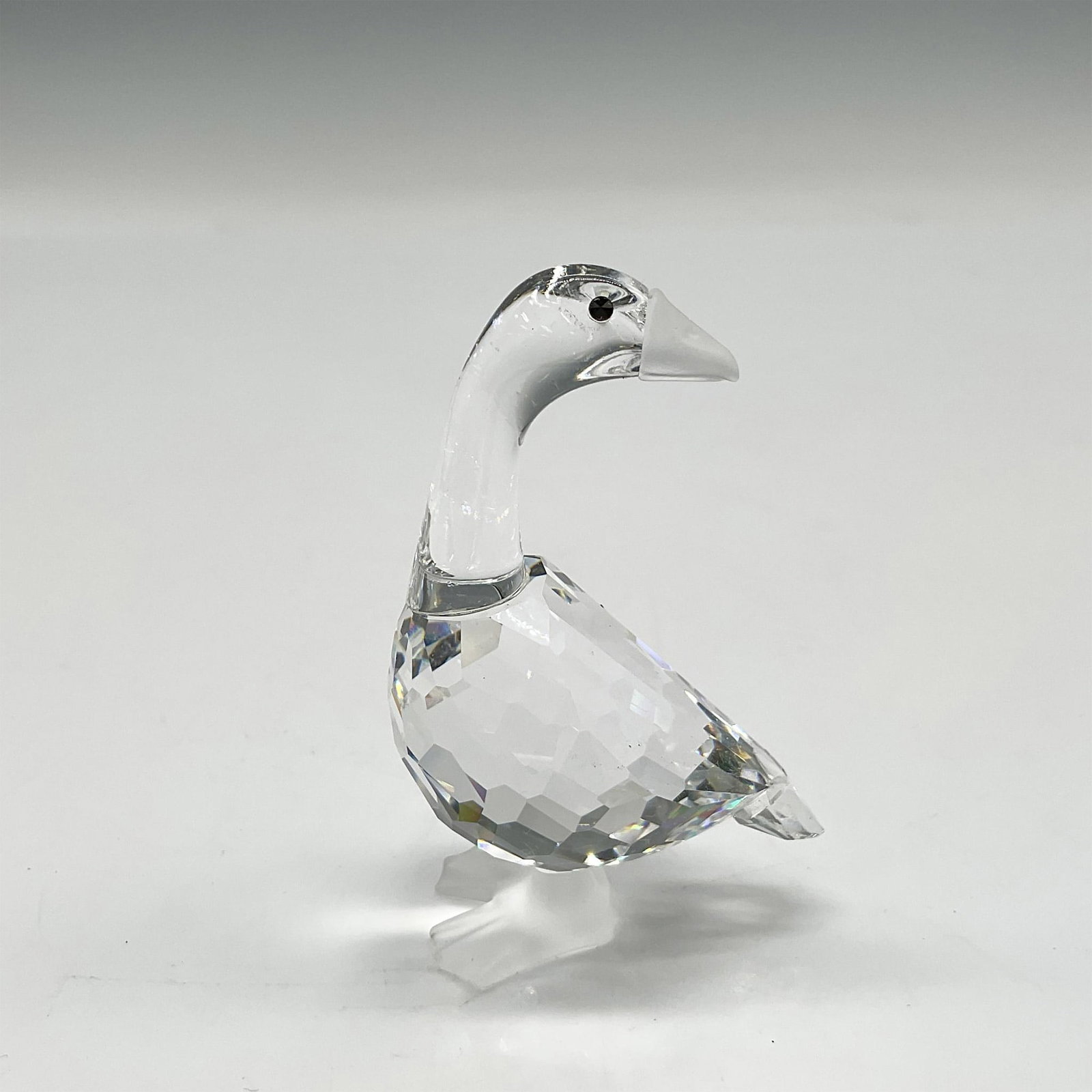 Swarovski Silver Crystal Figurine, Mother Goose: Part of the Barnyard Friends group, her body is clear facetted crystal, with jet crystal eyes with frosted crystal beak and feet. Swarovski backstamp. 7613 000 001. This item has its original box: 5"H