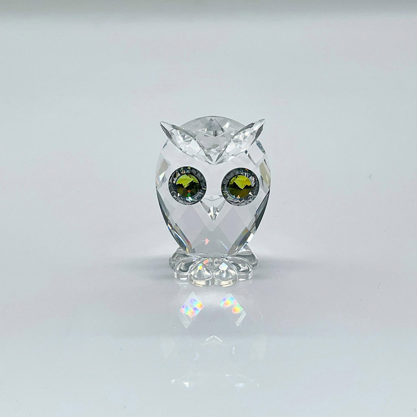 Swarovski Silver Crystal Figurine, Owl, Mini: Sparkling clear faceted crystal owl figure with green/blue/yellow eyes. Part of Woodland Friends collection. Swarovski mark. This item has its original box: 2.5"H x 3.25"dia. Issued: 1979-2011 Dimensi
