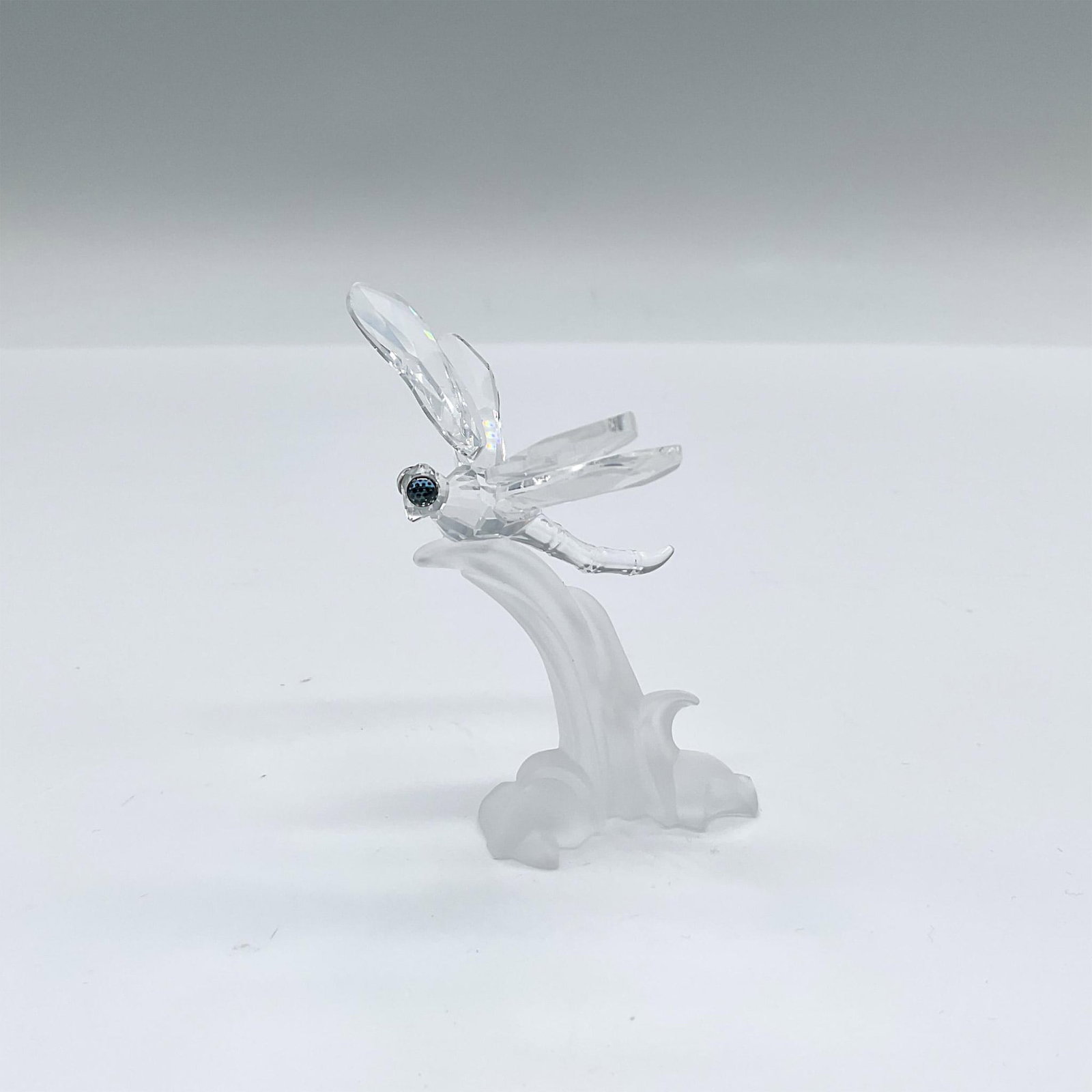 Swarovski Silver Crystal Figurine, Dragonfly: Part of the Among Flowers and Foliage theme group, and In The Secret Garden group. A clear body winged insect resting on a frost blade of glass. An interesting feature are the dragonfly's eyes, blue w