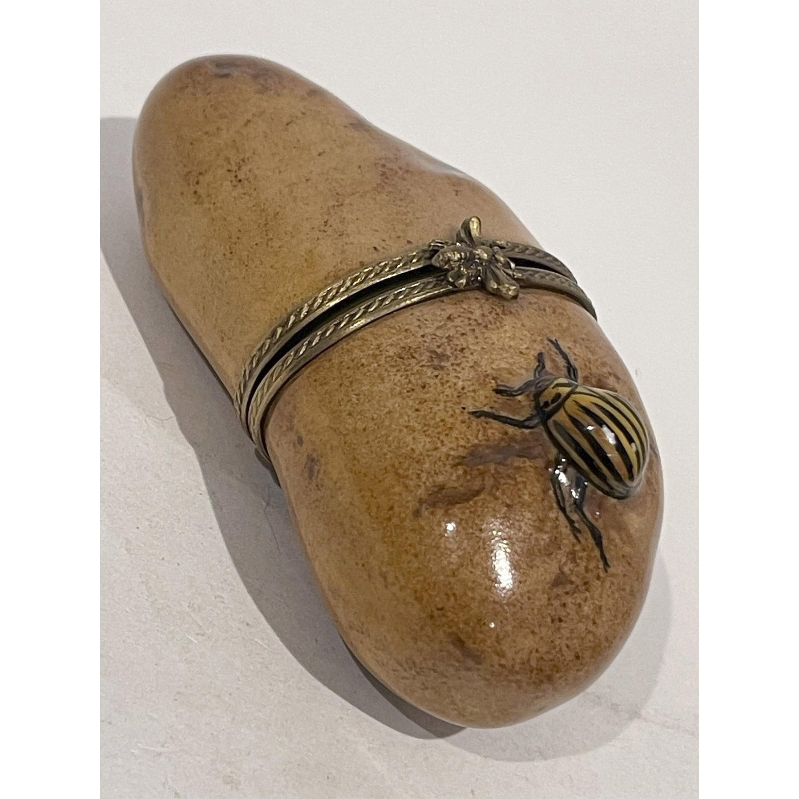Limoges France Keepsake Box, Potato with Colorado Beetle: Limited Edition. Realistically hand painted Brown potato replete with authentic Colorado potato beetle in tow mini Box with gilded bee at hinge opens to white interior. LS Peint Main MF Limoges France