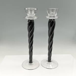 Pair of Kosta Boda Art Glass Candle Holders, Cypress: Striking combination of clear and onyx glass with twisted stem. Clear glass holder and base. Kosta Boda. Artist: Ann Wahlstrom Issued: 21st century Dimensions: 12"H x 4" dia. Manufacturer: Kosta Boda