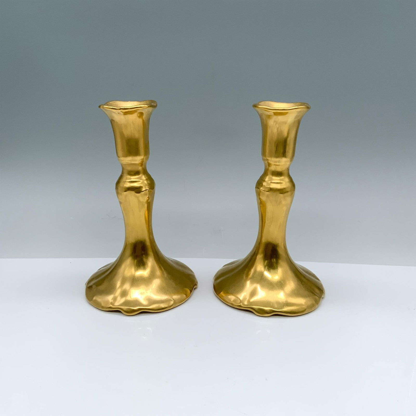 Pair of Elegant Gilded Candlesticks: Two beautiful gold tone candle holders with hallmarks on the inside. Dimensions: 4"dia. x 6.5"H