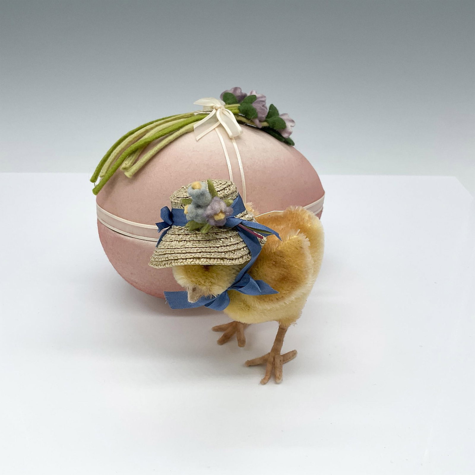 R. John Wright Springtime Friends Posey with Egg Box: This charming, handcrafted chick, wearing a bonnet, is enclosed within a beautiful Easter egg box adorned with delicate felted flowers. The hang tag is artist signed. Egg box measures 6"L x 3.5"W x 5"