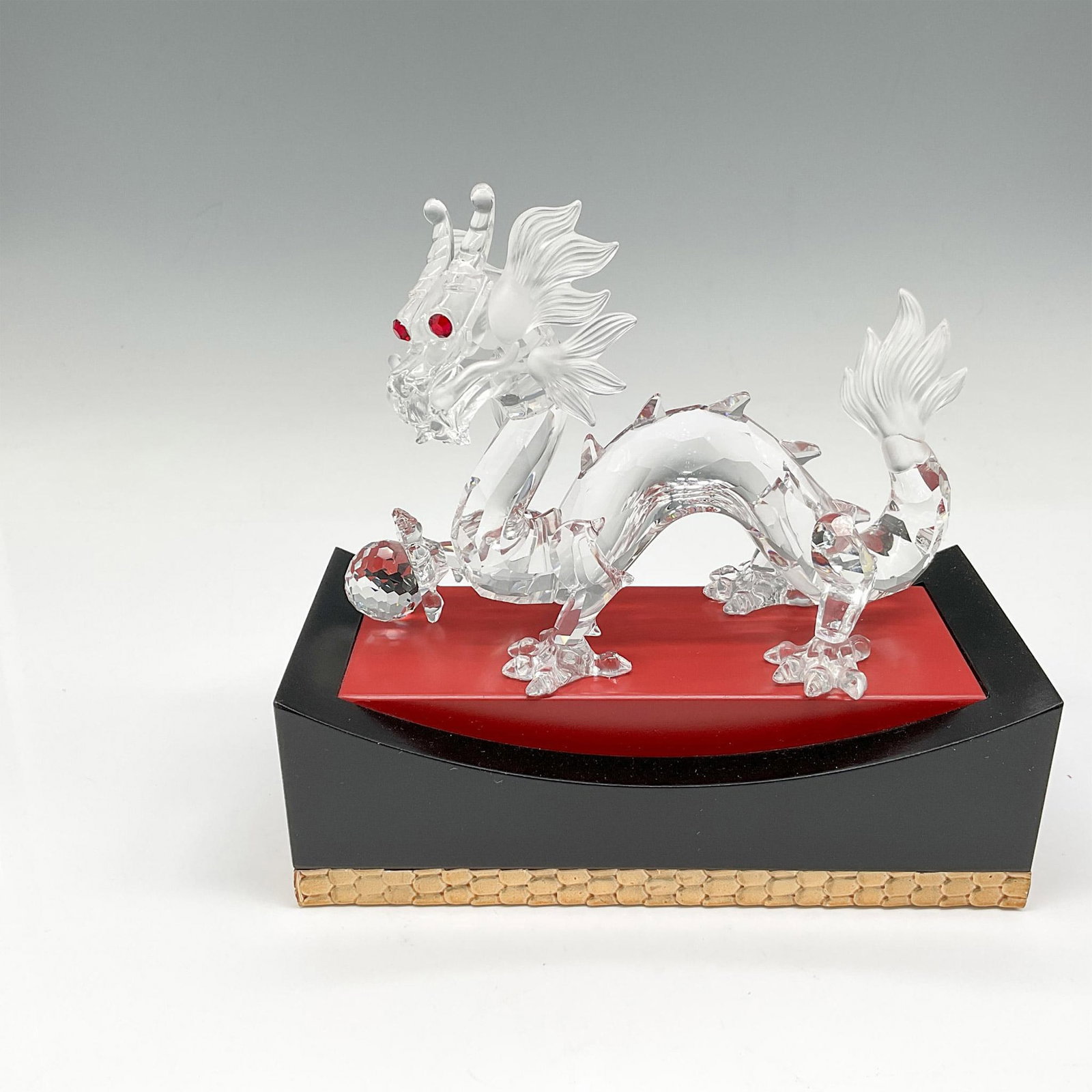 Swarovski SCS Crystal Figurine, 1997 Dragon + Base: Part of the Fabulous Creatures trilogy, figural is created from clear crystal looking out with his red crystal eyes with foot perched on his crystal. He is accented with satin crystal whiskers, mane a