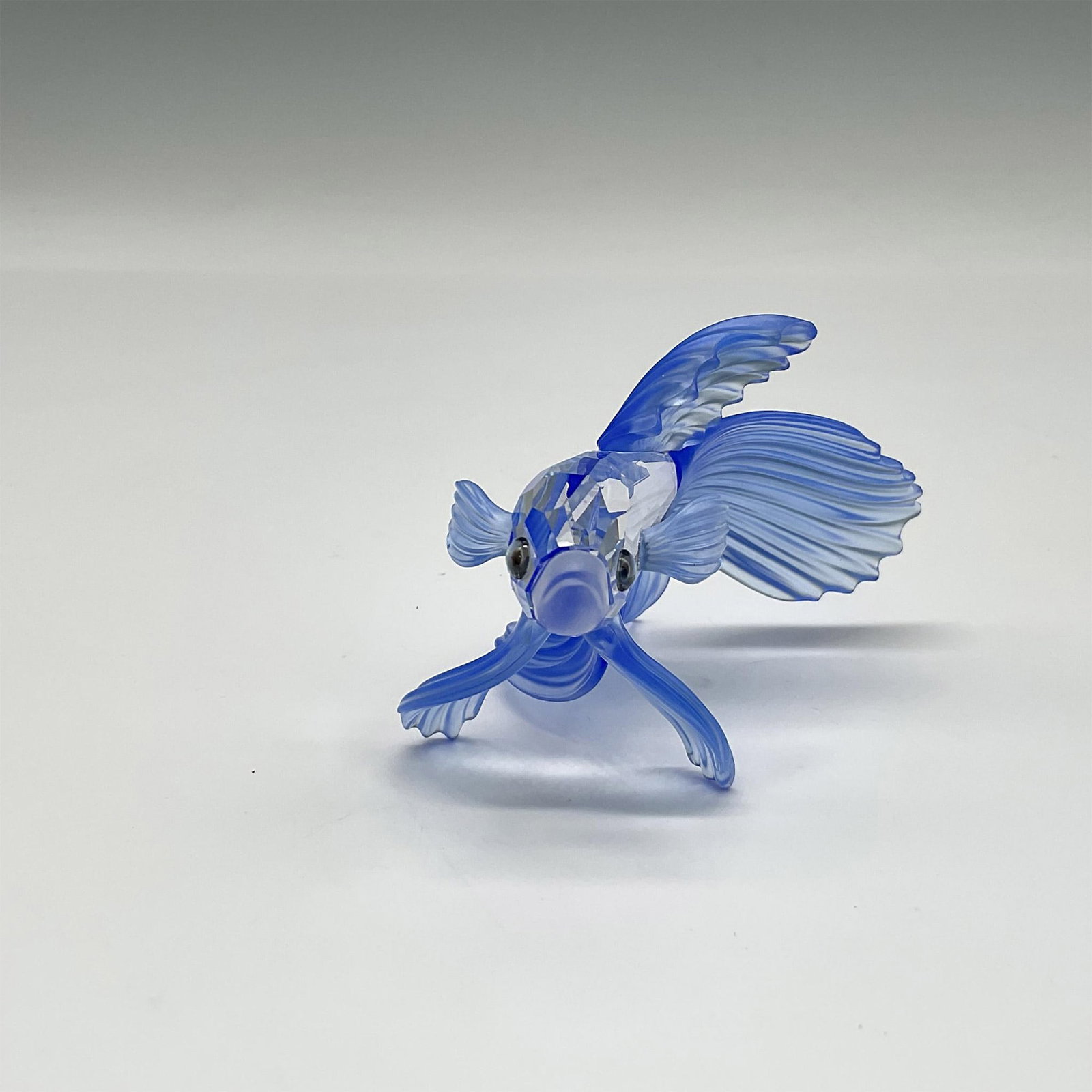 Swarovski SC Figurine, Siamese Fighting Fish Blue: Part of the South Sea group, figural has a clear crystal body, satin crystal mouth with blue satin crystal fins and tail. Swarovski backstamp. 7644 000 005. This item has its original box: 4"H x 5" di