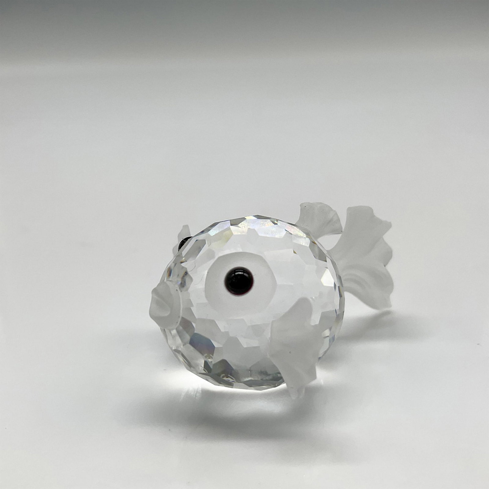 Swarovski Silver Crystal Figurine, Mini Blowfish: Mini crystal figural is a member of the South Sea theme group. Faceted crystal body with frosted crystal fins, tail, mouth and around his jet crystal eyes. Swarovski backstamp. 7668 020 000. This item