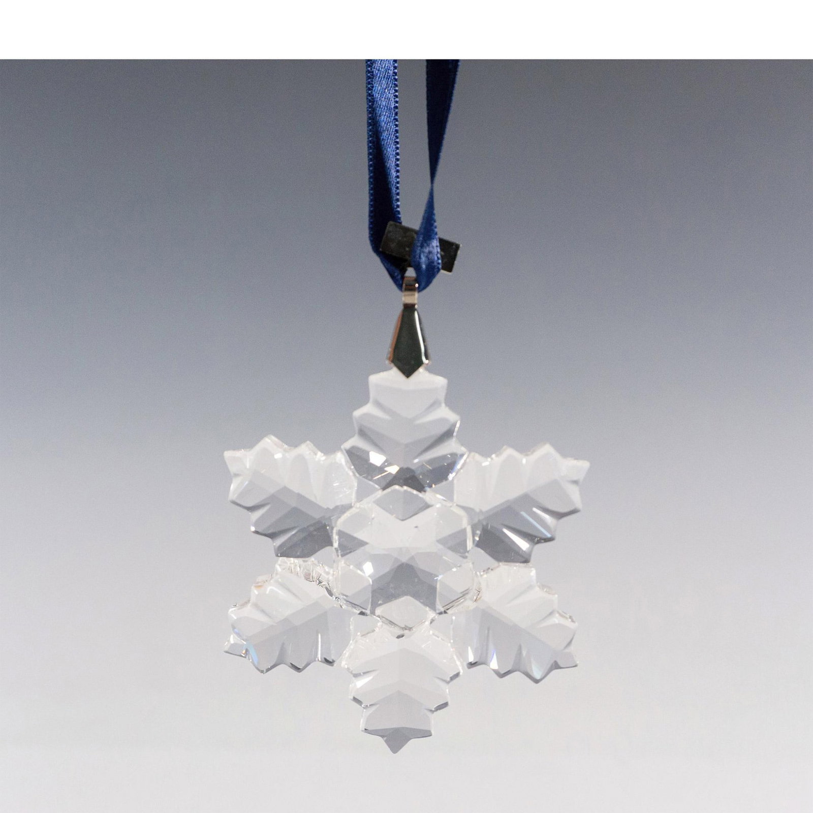 Swarovski Crystal 1996 Christmas Ornament: A clear tree ornament with 6 points in a form of a leaf-life design, and a metal tag with 1996 etched on it. Swarovski marked. This item has its original box: 6"L x 5.25"W x 1"H. Artist: Martin Zendro