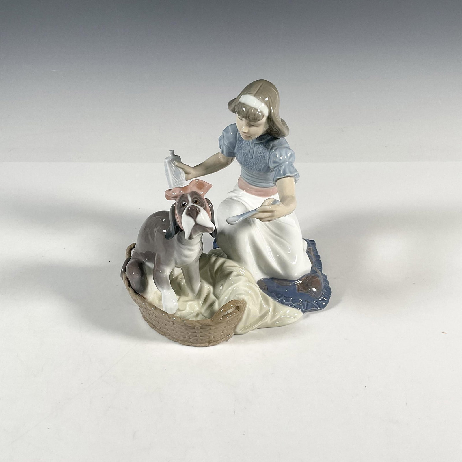 Take Your Medicine 1005921 - Lladro Porcelain Figurine: Glossy finish; Lladro backstamp. Includes original box 10"L x 9"W x 8"H. Artist: Regino Torrijos Issued: 1992 - 1998 Dimensions: 7.5"H x 7"W Manufacturer: Lladro Country of Origin: Spain