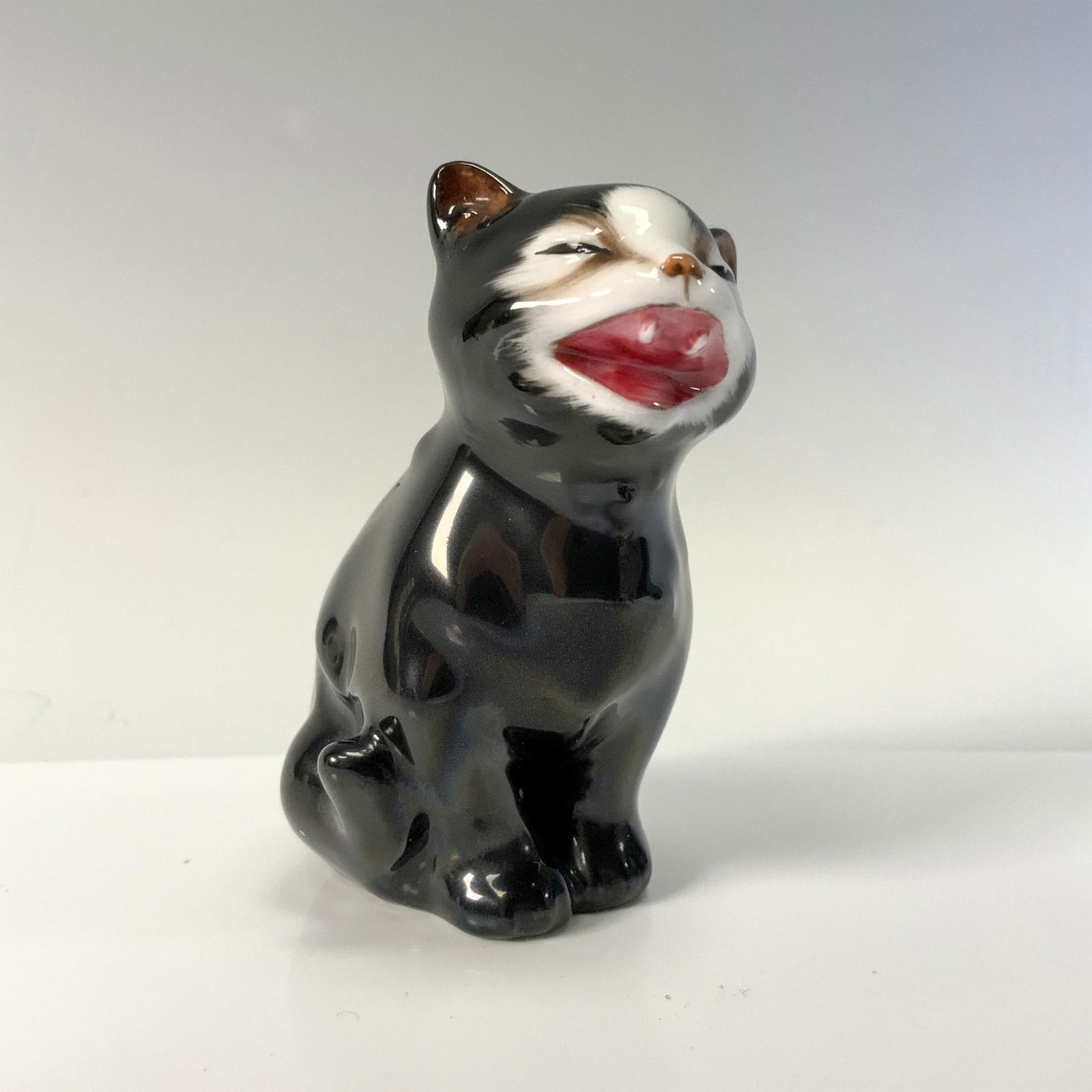 Lucky Black Cat K12 - Royal Doulton Animal Figures: Glossy figural with black fur and white face that is meowing. Royal Doulton backstamp. Artist: Charles Noke Issued: 1932–1975 Dimensions: 1.5"L x 1.5"W x 2.5"H Manufacturer: Royal Doulton Country of