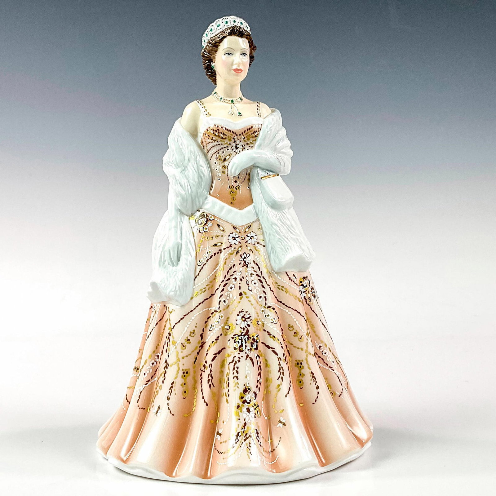 Queen Elizabeth II HN5706 From the Young Queens Collection - Royal Doulton Figurine: A porcelain figure of Queen Elizabeth wearing a cream colored dress and white shawl. Young Queens series. Limited edition, 1189 of 2000. Royal Doulton backstamp. Artist: Neil Faulkner Issued: 2014 Dim