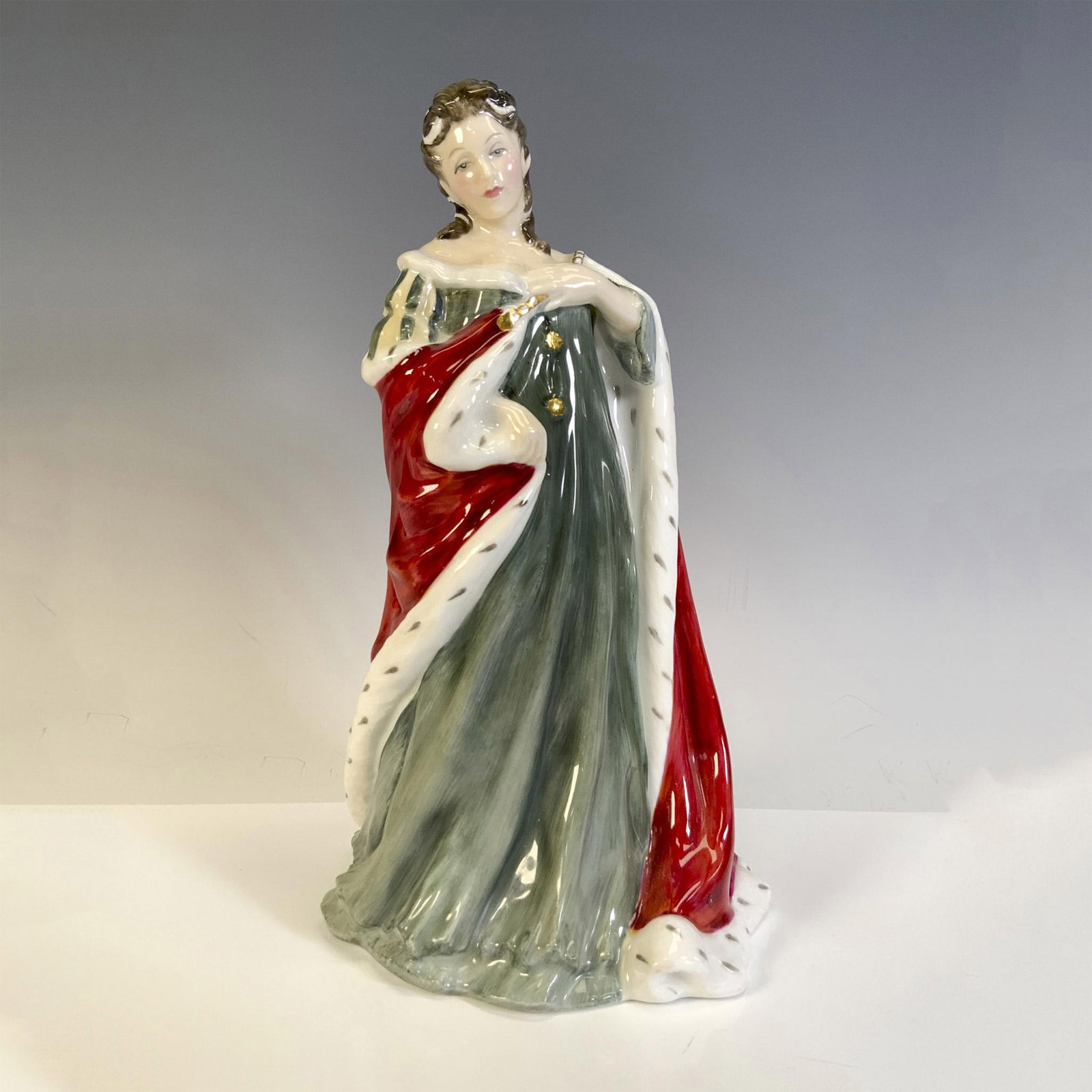 Queen Anne HN3141 - Royal Doulton Figurine: Part of the Queens of the Realm series. Figural is a limited edition, 3228 of 5000, dressed in royal colors, green gown with red robe. Royal Doulton backstamp. Artist: Pauline Parsons Issued: 1988 Dim