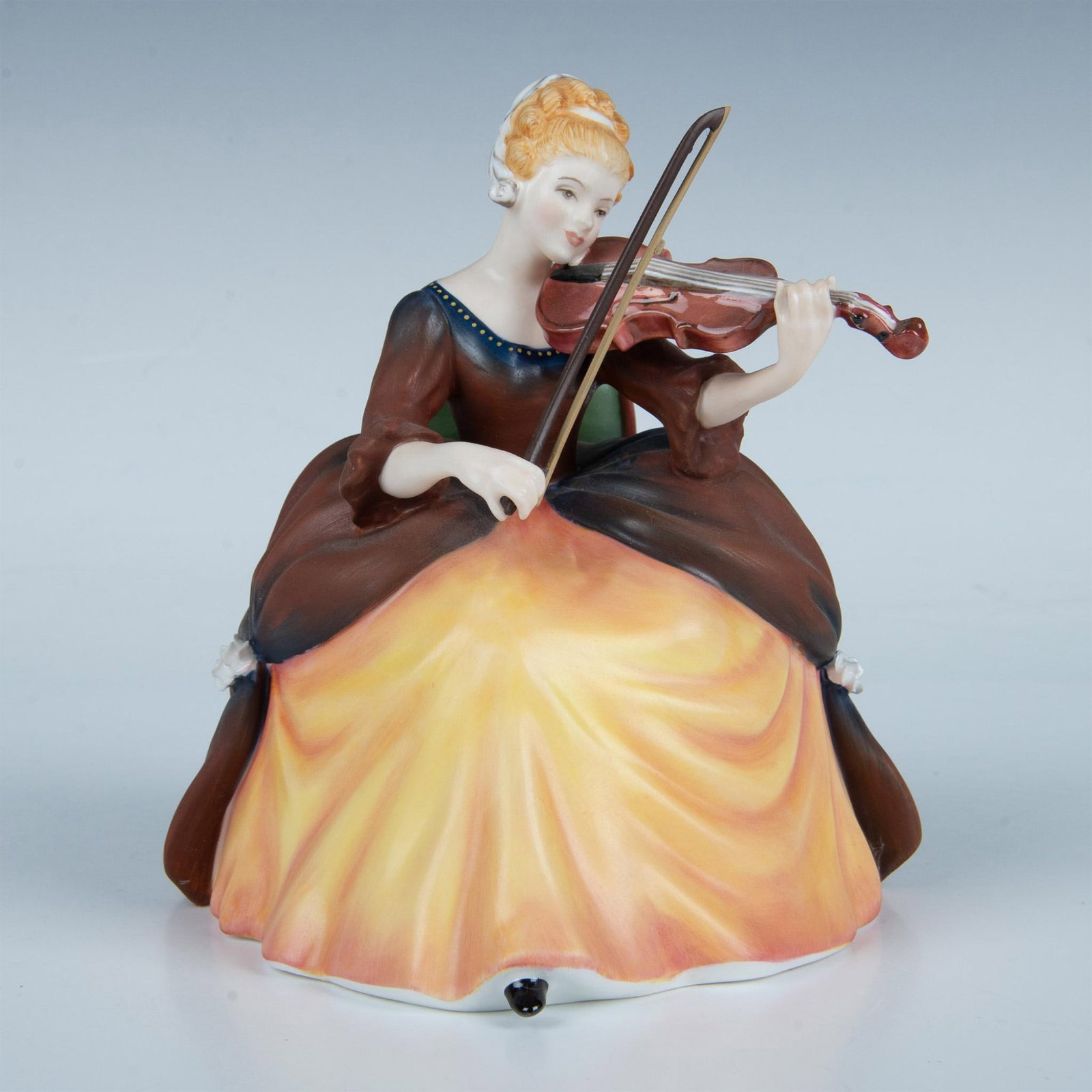 Violin HN2432 - Royal Doulton Figurine: Limited edition in matte finish part of the Lady Musicians series. She wears a brown and gold 18th-century gown while playing the violin. Royal Doulton backstamp. This item has its original box. Box m