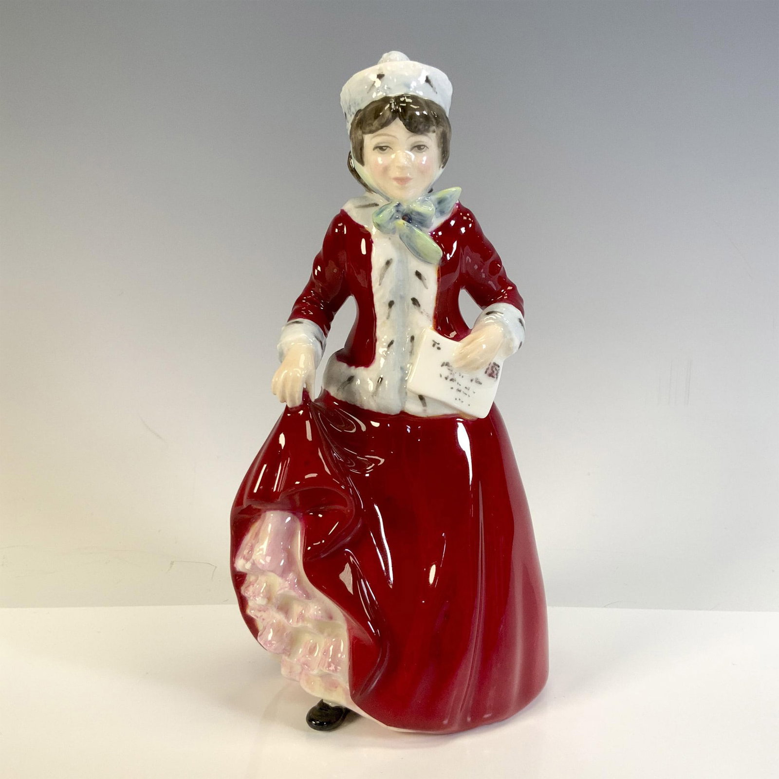 Best Wishes HN3426 - Royal Doulton Figurine: Young glossy figural dressed in red for the holidays. Royal Doulton backstamp. Artist: Nada Pedley Issued: 1993 - 1995 Dimensions: 3.25"L x 3"W x 6.5"H Manufacturer: Royal Doulton Country of Origin:<