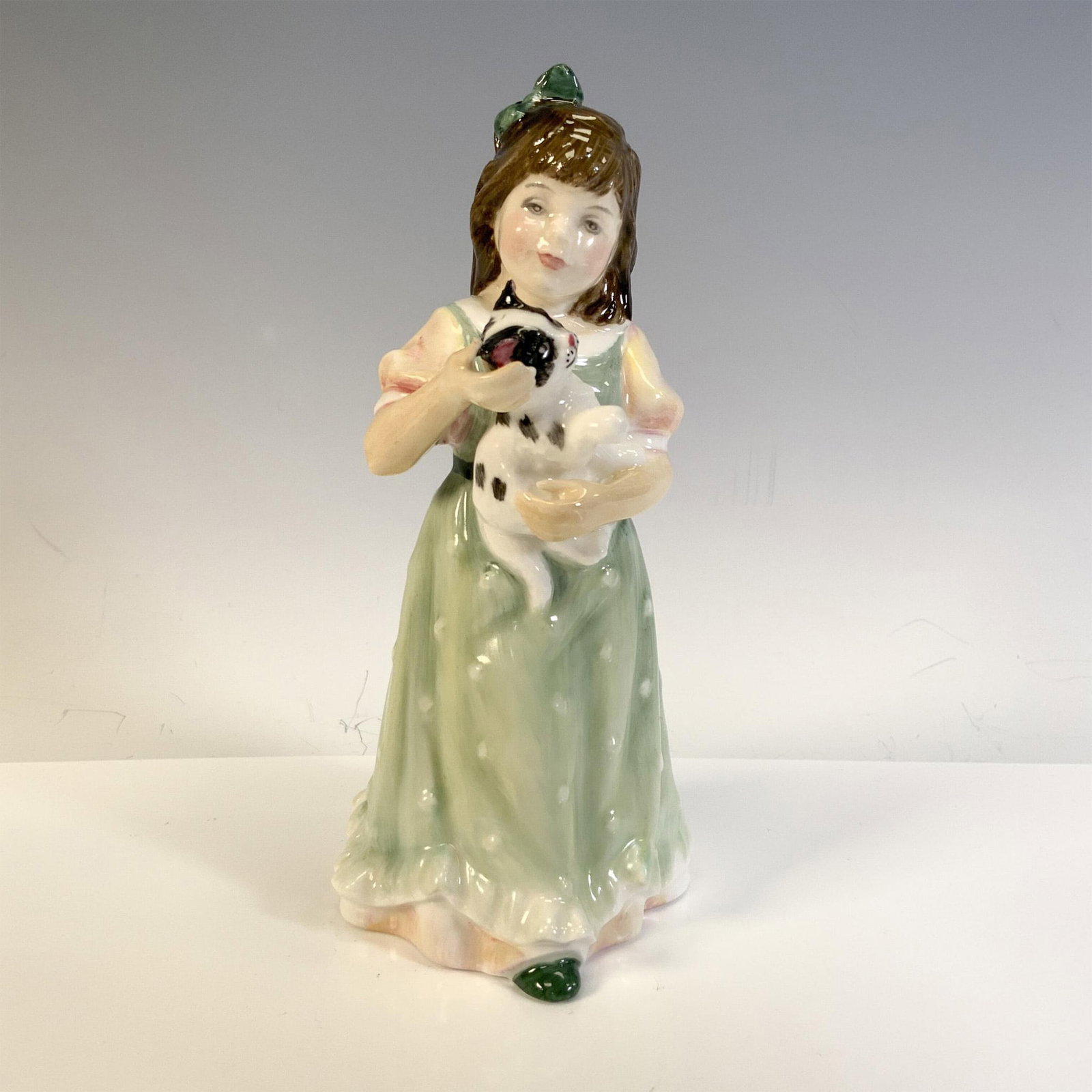 Home At Last HN3697 - Royal Doulton Figurine: Young glossy figural holding her cat. Royal Doulton backstamp. Artist: Nada Pedley Issued: 1995 - 1999 Dimensions: 2.75"L x 3"W x 6"H Manufacturer: Royal Doulton Country of Origin: England