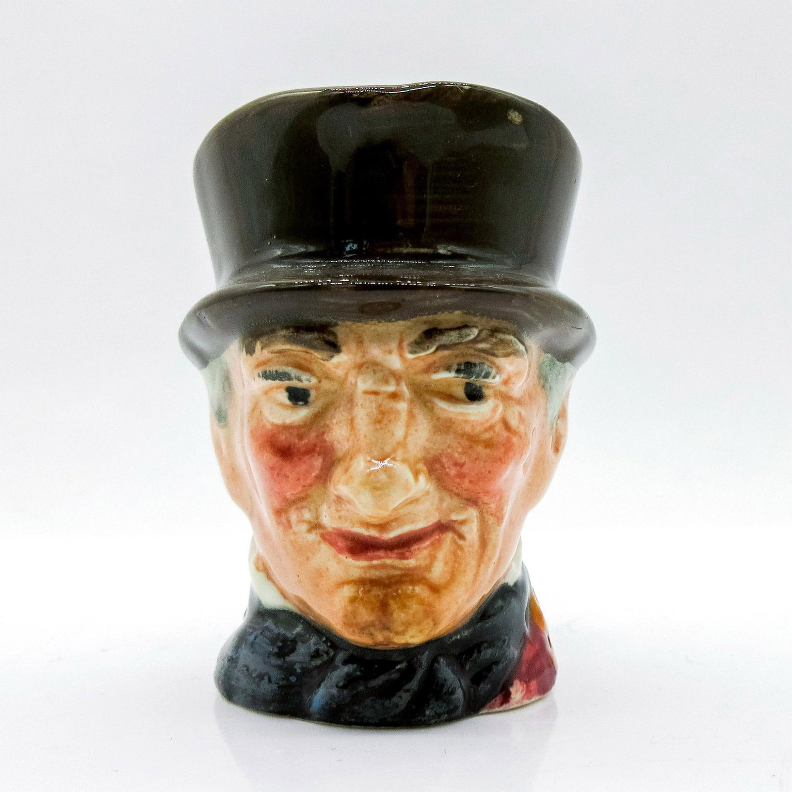 John Peel D6130 (Orange and Black Handle) - Mini - Royal Doulton Character Jug: Variation Two, black and orange handle. Dark grey hat; maroon coat; dark blue bow tie; black and orange riding crop. John Peel (1776 - 1854) was a famous English huntsman, known for his enthusiasm, sk