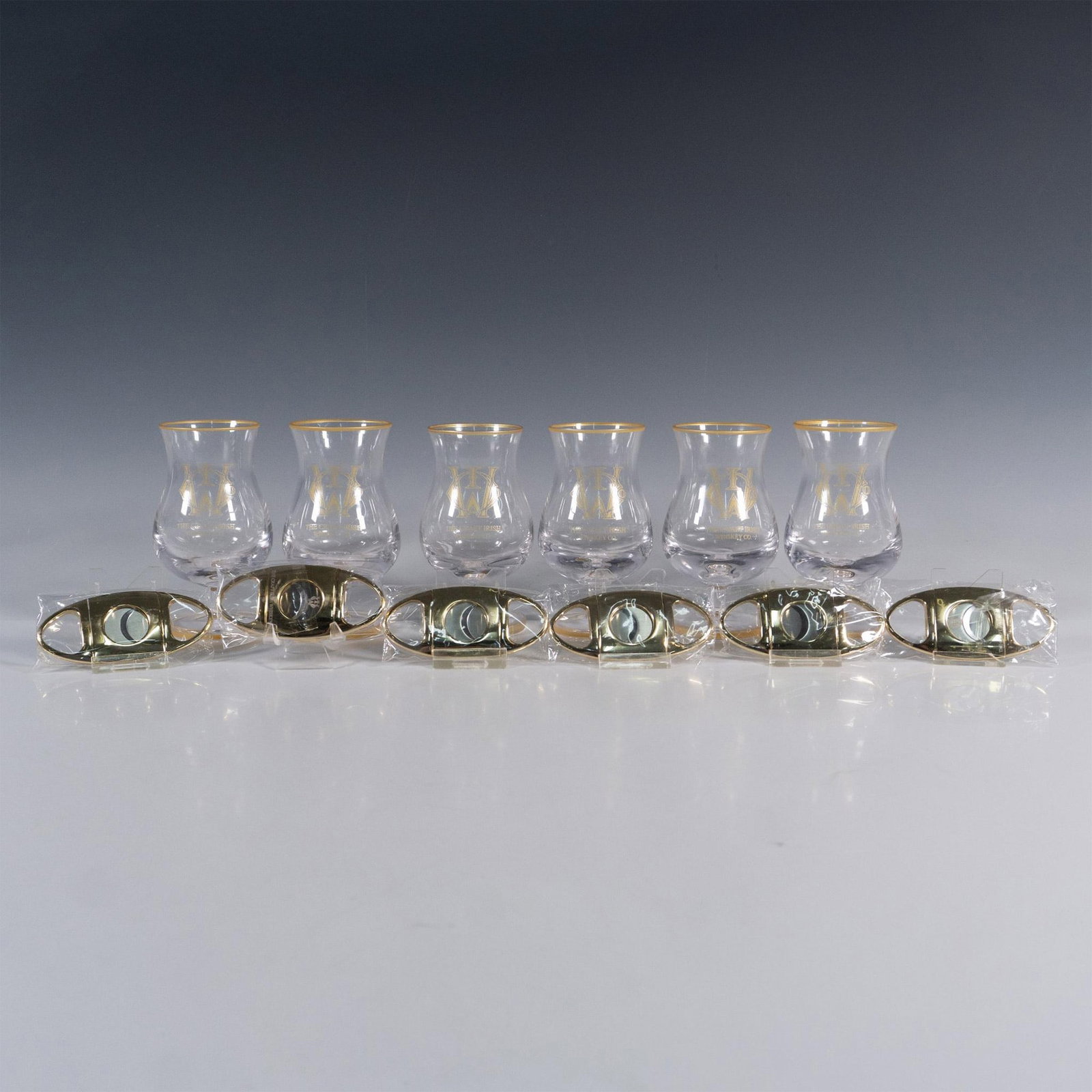 12pc The Craft Irish Whiskey Co. Finn Glass Set: This distinguished collection by The Craft Irish Whiskey Co. proudly showcases their logo and includes 6 Finn whiskey tasting glasses and 6 sleek cigar cutters, perfect for gifting at your next whiske
