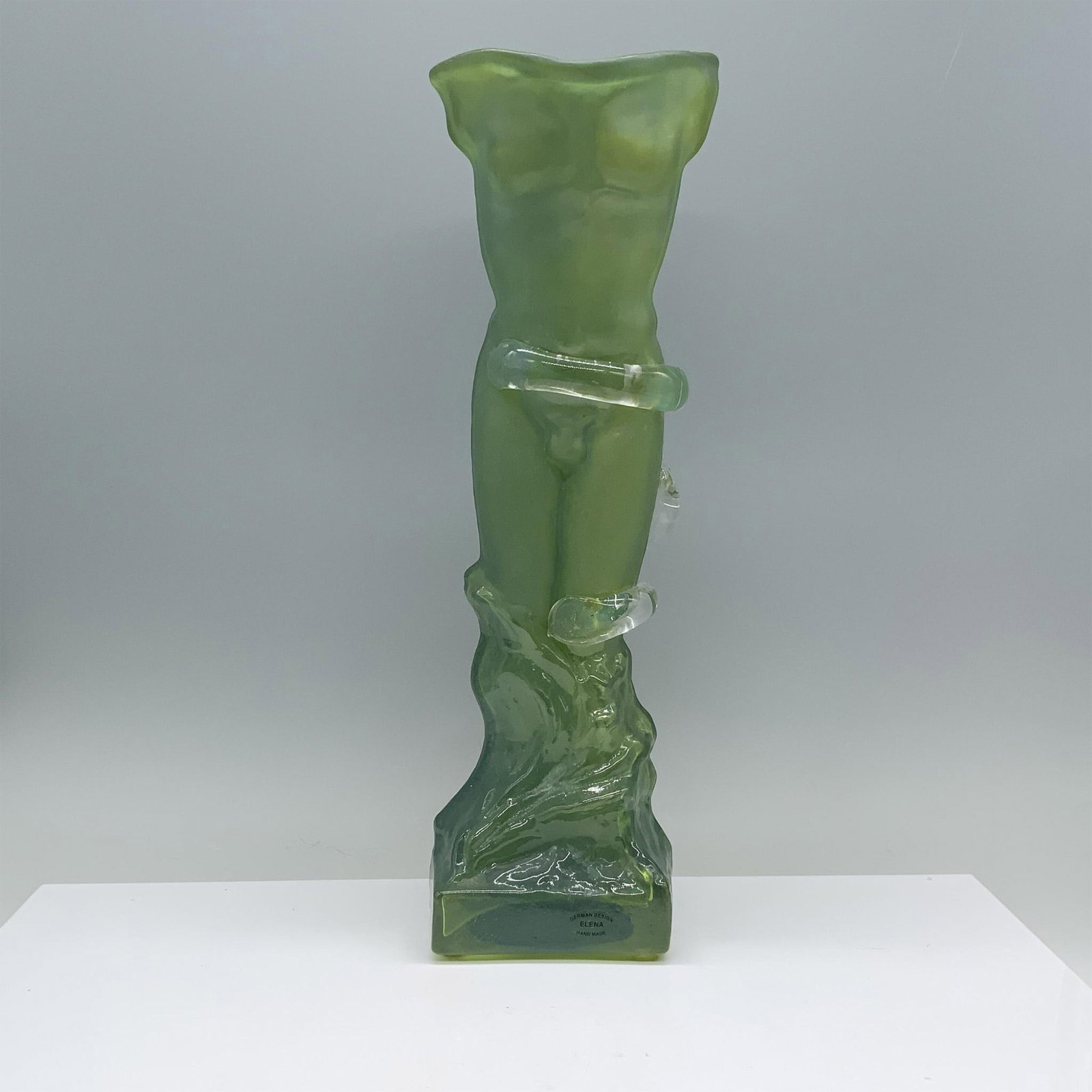 Elena German Design Figural Male Art Glass Vase: Beautiful frosted green vase depicting a nude male torso. Artist signature on the front of the base. Dimensions: 4.25"L x 4"W x 14.75"H Country of Origin: Germany