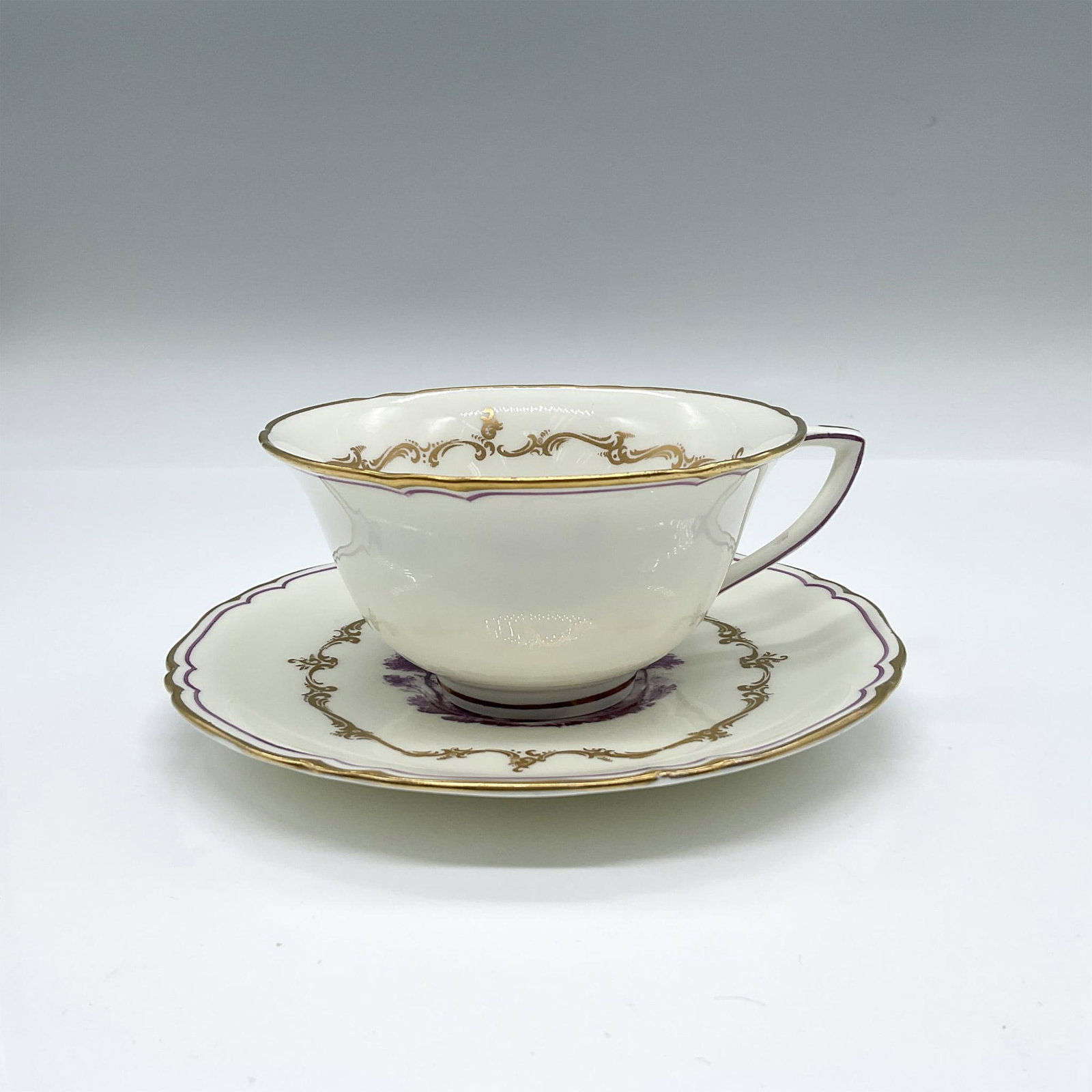 Royal Worcester Bone China Cup and Saucer, The Chamberlain: A white cafe set with gilt and purple trims, and features two different landscapes in purple. Royal Worcester backstamps. Cup: 5"L x 4.25"W x 2.25"H. Saucer: 5.75"W x 0.5"H. Issued: 1950s Manufacturer