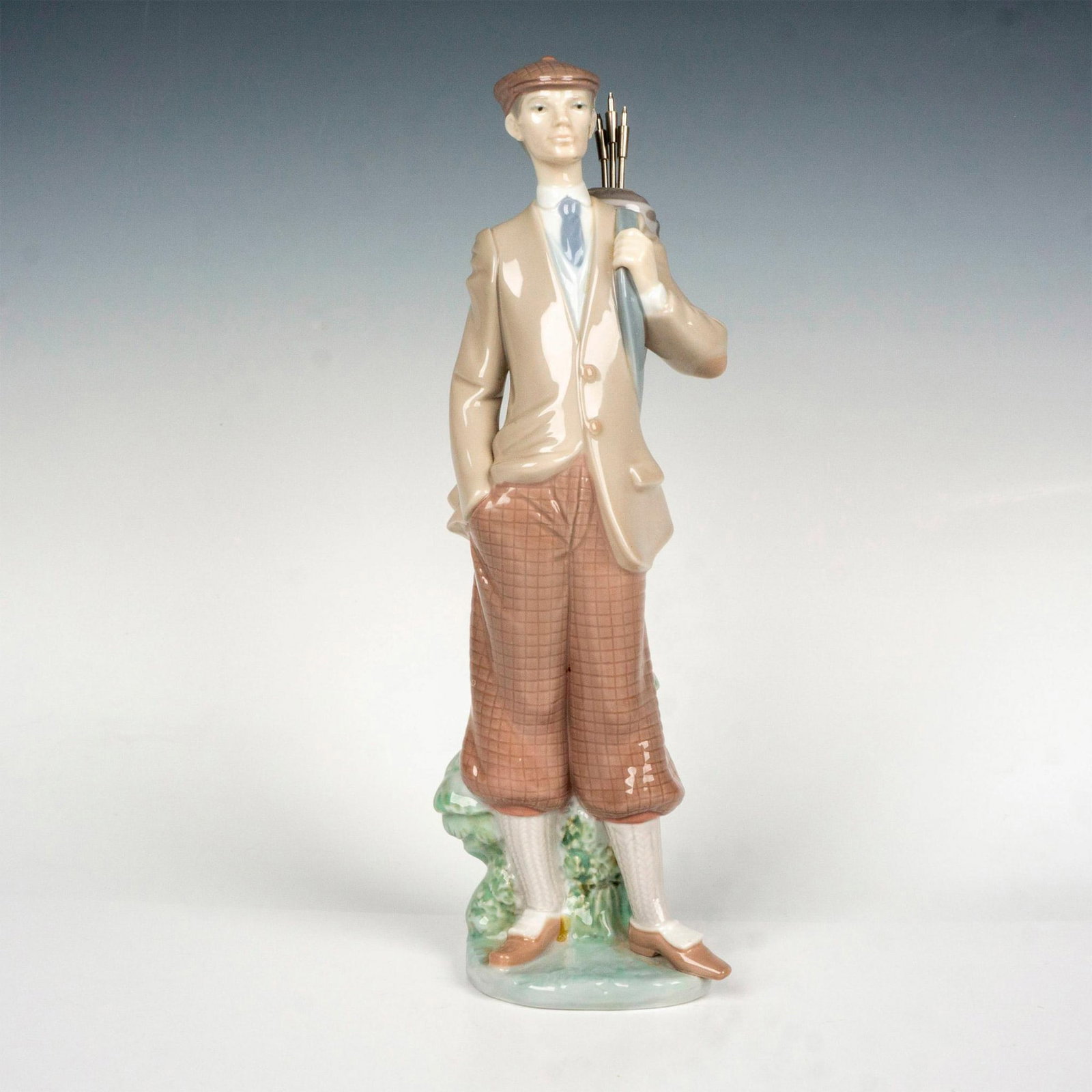 Waiting To Tee Off 1005301 - Lladro Porcelain Figurine: Glossy finish; Lladro backstamp. Artist: Juan Huerta Issued: 1985 - 1999 Dimensions: 11.5"H x 3.5"W Manufacturer: Lladro Country of Origin: Spain
