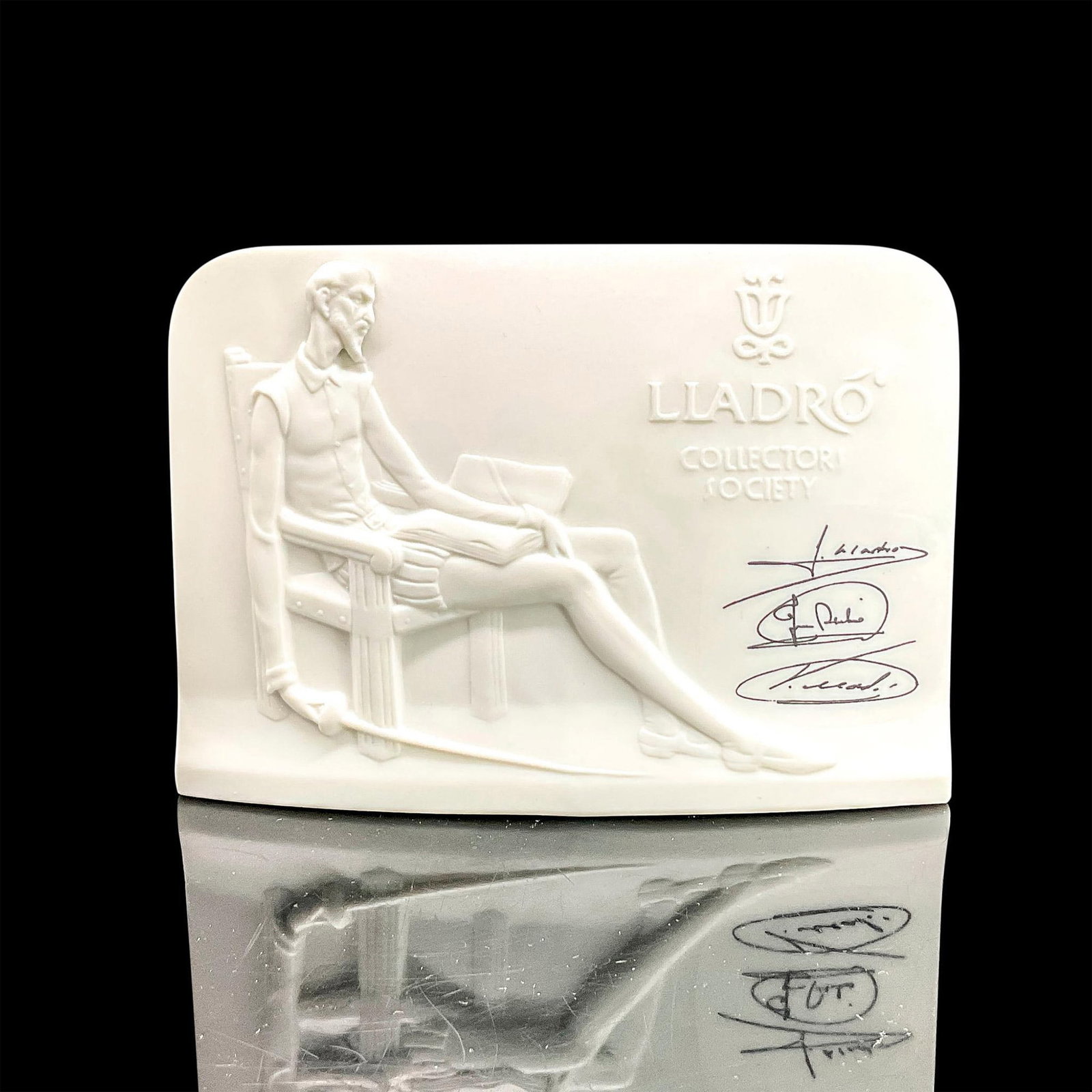 Display Sign, Don Quixote - Lladro Collectors Society: Matte porcelain display sign with image of a seated Don Quixote in low-relief. Lladro backstamp. Issued: 1985 Dimensions: 6"L x 2.25"W x 4.25"H Manufacturer: Lladro Country of Origin: Spain