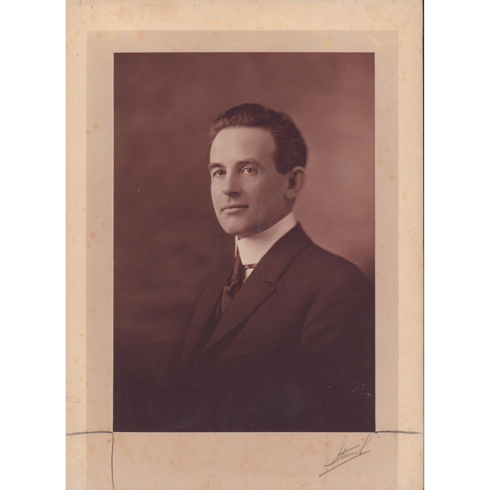 Antique Photograph of Victorian Man: Black and white portrait of a dark haired man dressed elegantly, posing for photo. Hand signed in pencil on bottom right corner. Dimensions: 7.75"W x 10.75"H