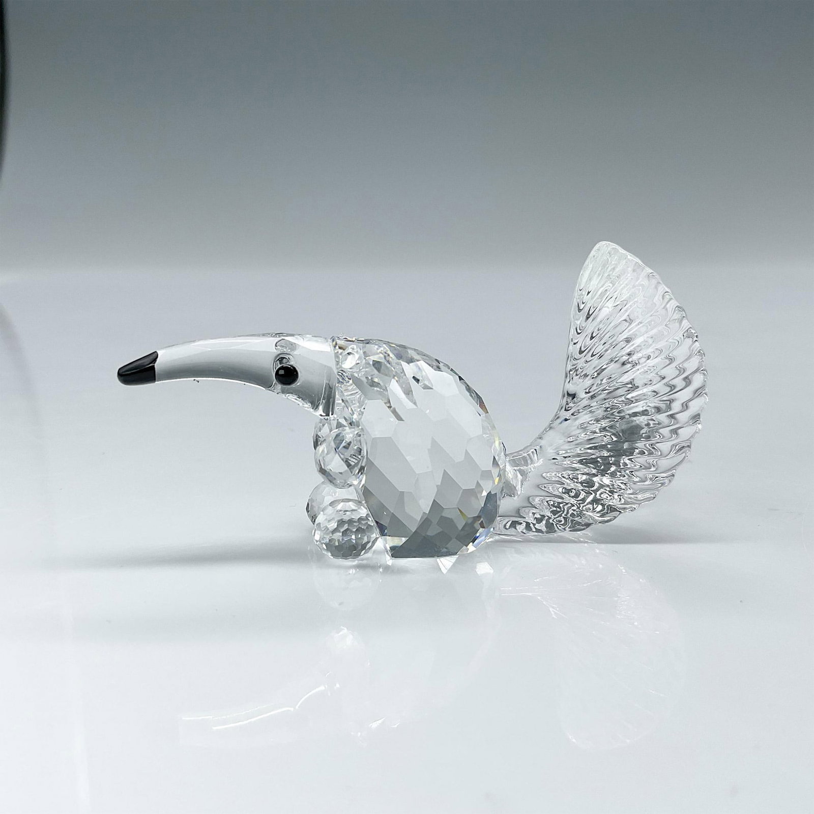 Swarovski Silver Crystal Figurine, Anteater: Lead crystal faceted crystal with molded tail. Swarovski etched backstamp. This item has its original box. Box measures: 2.5"H x 3.25" dia. Artist: Adi Stocker Issued: 2001-2006 Dimensions: 2.25"L x 0
