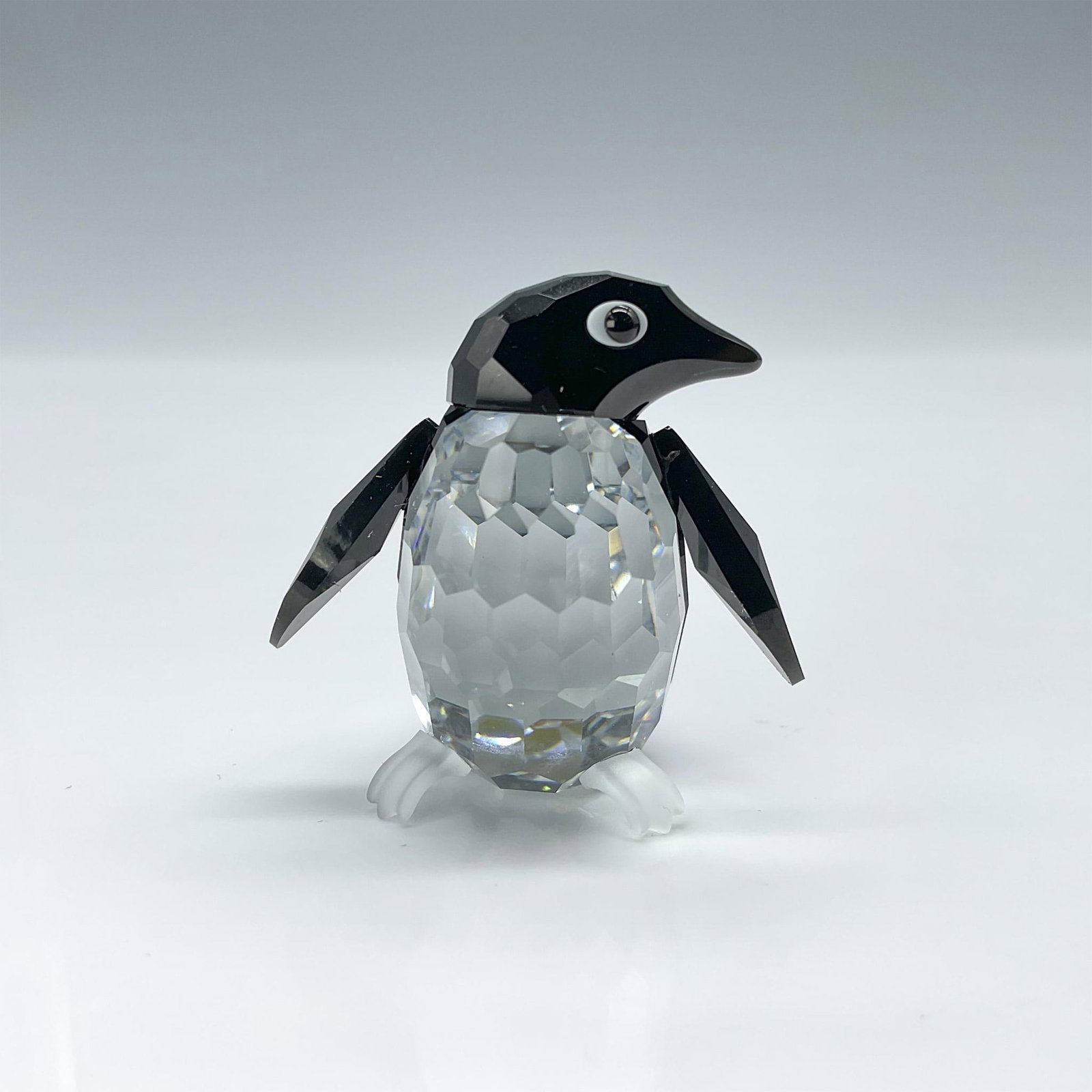 Swarovski Crystal Figurine, Penguin Madame: This crystal Madame Penguin, part of the Kingdom of Ice and Snow collection, is crafted from clear and black crystal. Adorned with white crystal around its eyes and featuring frosted feet, mirror-coat
