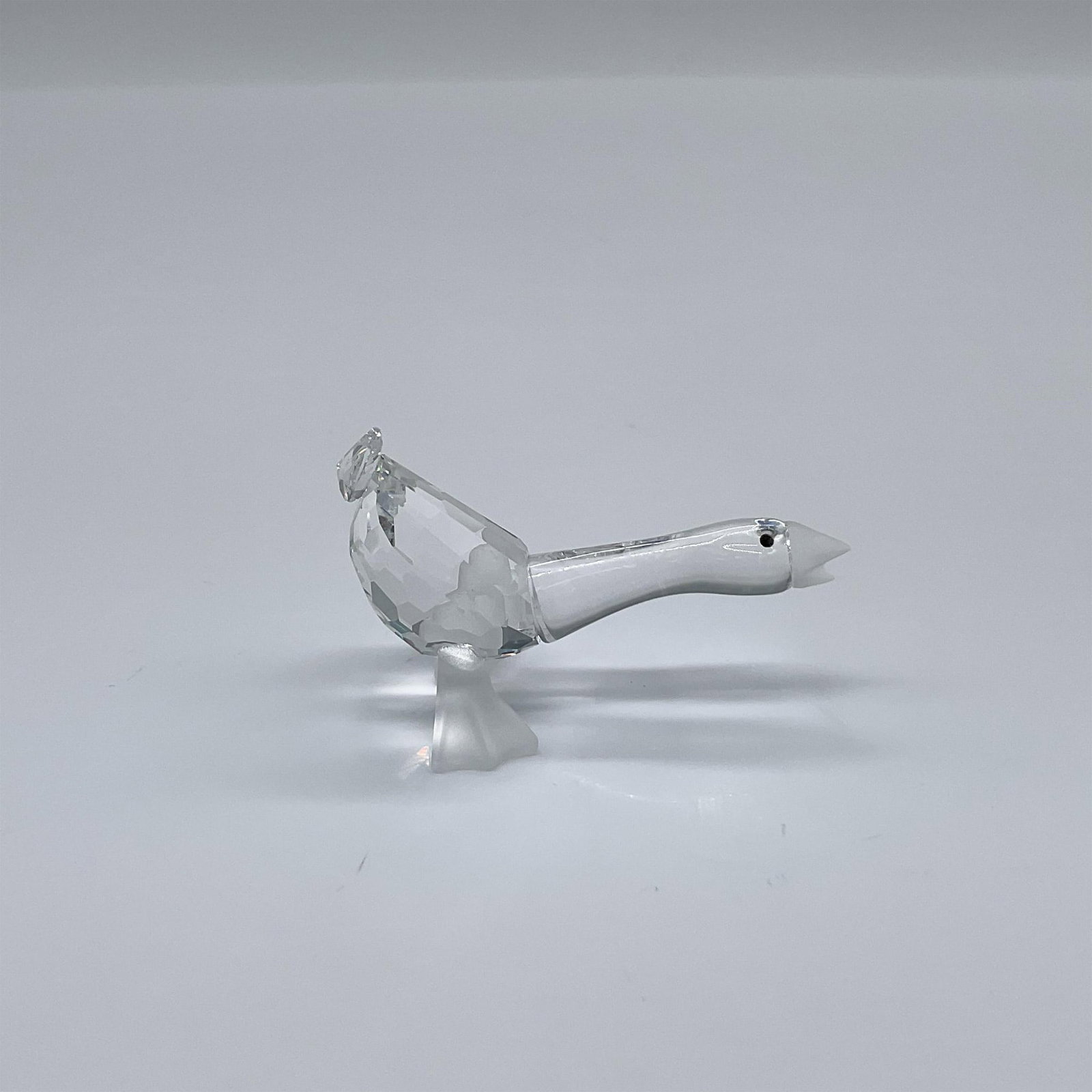 Swarovski Crystal Figurine, Gosling Harry: Part of the Barnyard Friends theme group. A duck in a clear facetted crystal, black eyes, and frosted crystal beak and feet. Swarovski Crystal swan logo on Harry's feet. This item has its original box