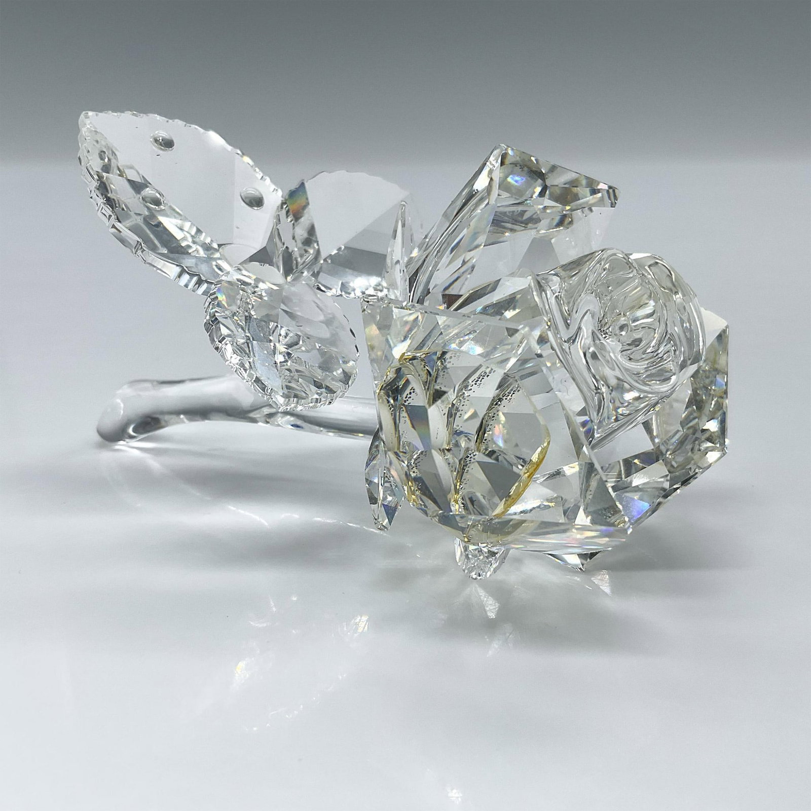 Swarovski Crystal Figurine, Rose Blossom 890289: Clear lead crystal elegant figure of a bloomed rose. Swarovski etched backstamp. This item has its original box which measures: 5"H x 6" dia. Artist: Michael Stamey Issued: 1993-2007 Dimensions: 3.25"