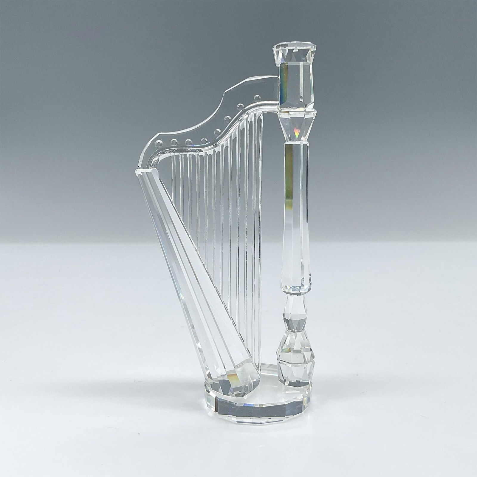 Swarovski Crystal Figurine, Harp: Part of the Crystal Melodies collection and is made from full lead clear crystal. Swarovski etched backstamp. Artist: Martin Zendron Issued: 1992-1998 Dimensions: 2"L x 1.25"W x 4"H Manufacturer: Swar