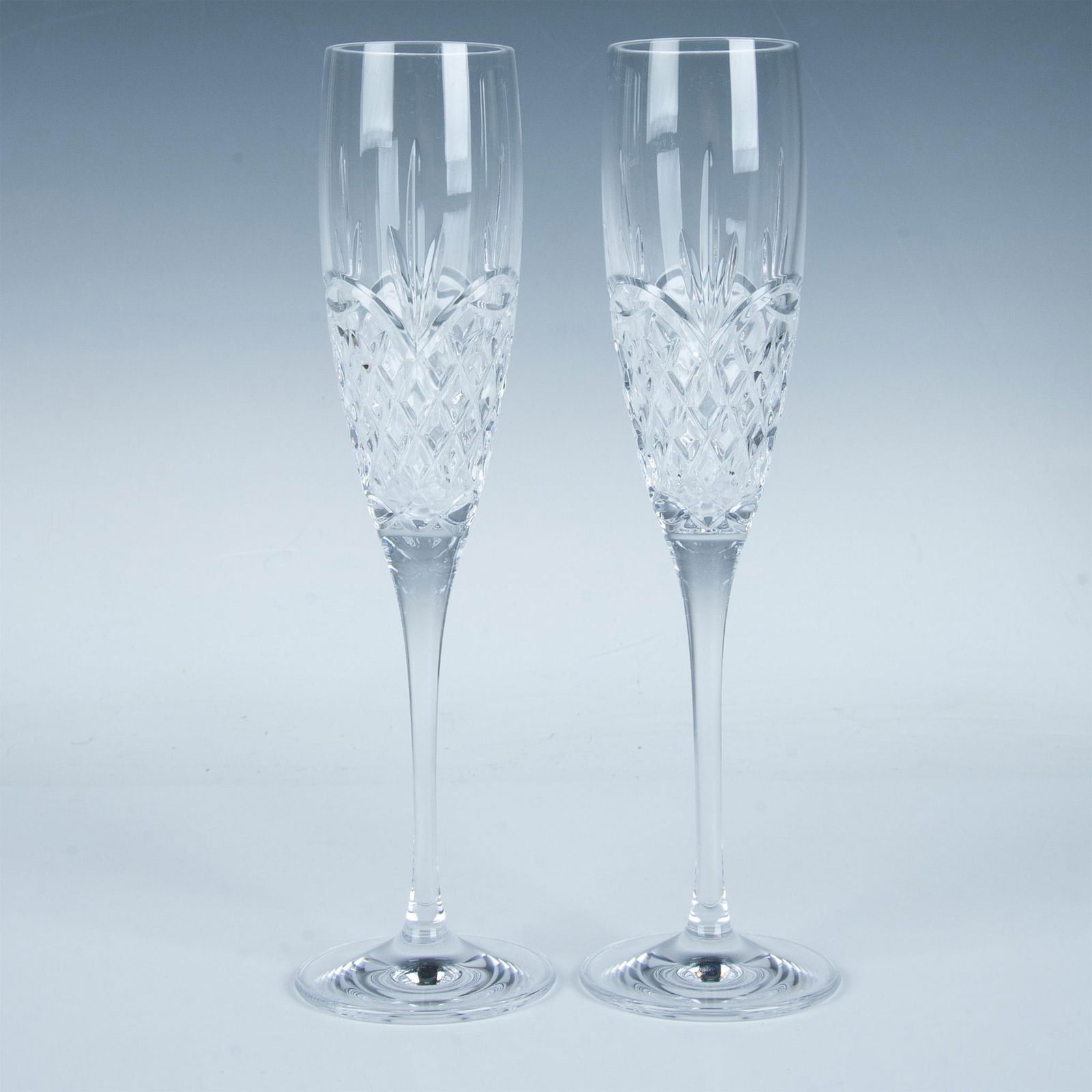 Waterford Crystal Champagne Flutes, Love Flutes: A pair of tulip-shaped, hand-cut and polished champagne toasting flutes adorned with a crisscross and feather motif. This item has its original box which measures 9.75"L x 12.75"H. Waterford backstamp