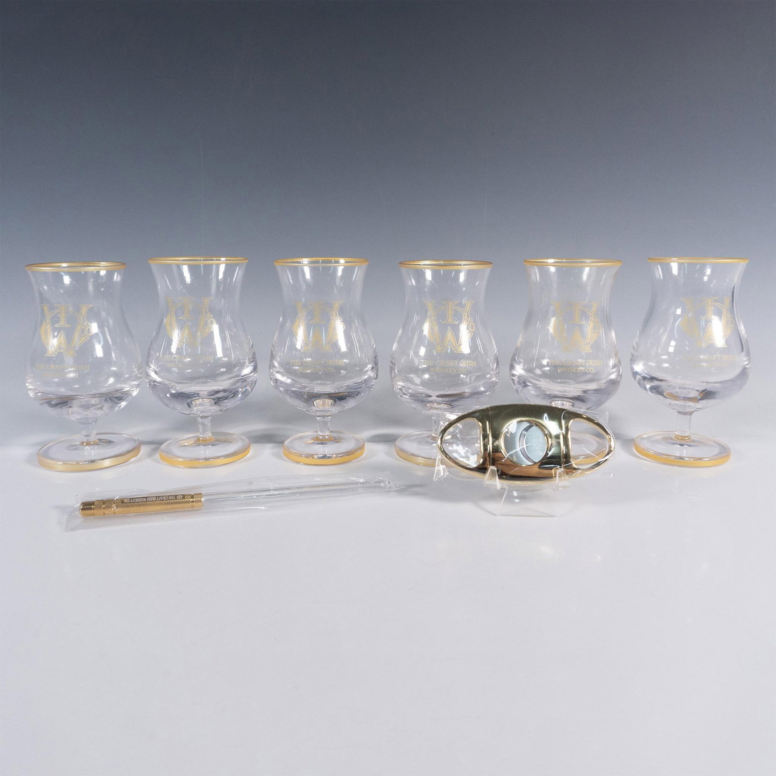 8pc The Craft Irish Whiskey Co. Finn Glass Set: This distinguished collection by The Craft Irish Whiskey Co. proudly showcases their logo and includes 6 Finn whiskey tasting glasses, an elegant pipette, and a sleek cigar cutter, ensuring an elevate