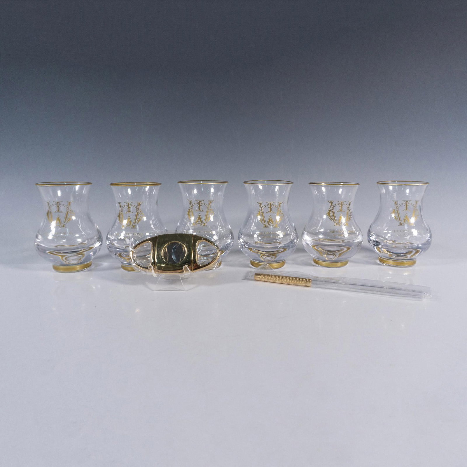 8pc The Craft Irish Whiskey Co. Erimon Glass Set: This distinguished collection by The Craft Irish Whiskey Co. proudly showcases their logo and includes 6 Erimon whiskey tasting glasses, an elegant pipette, and a sleek cigar cutter, ensuring an eleva