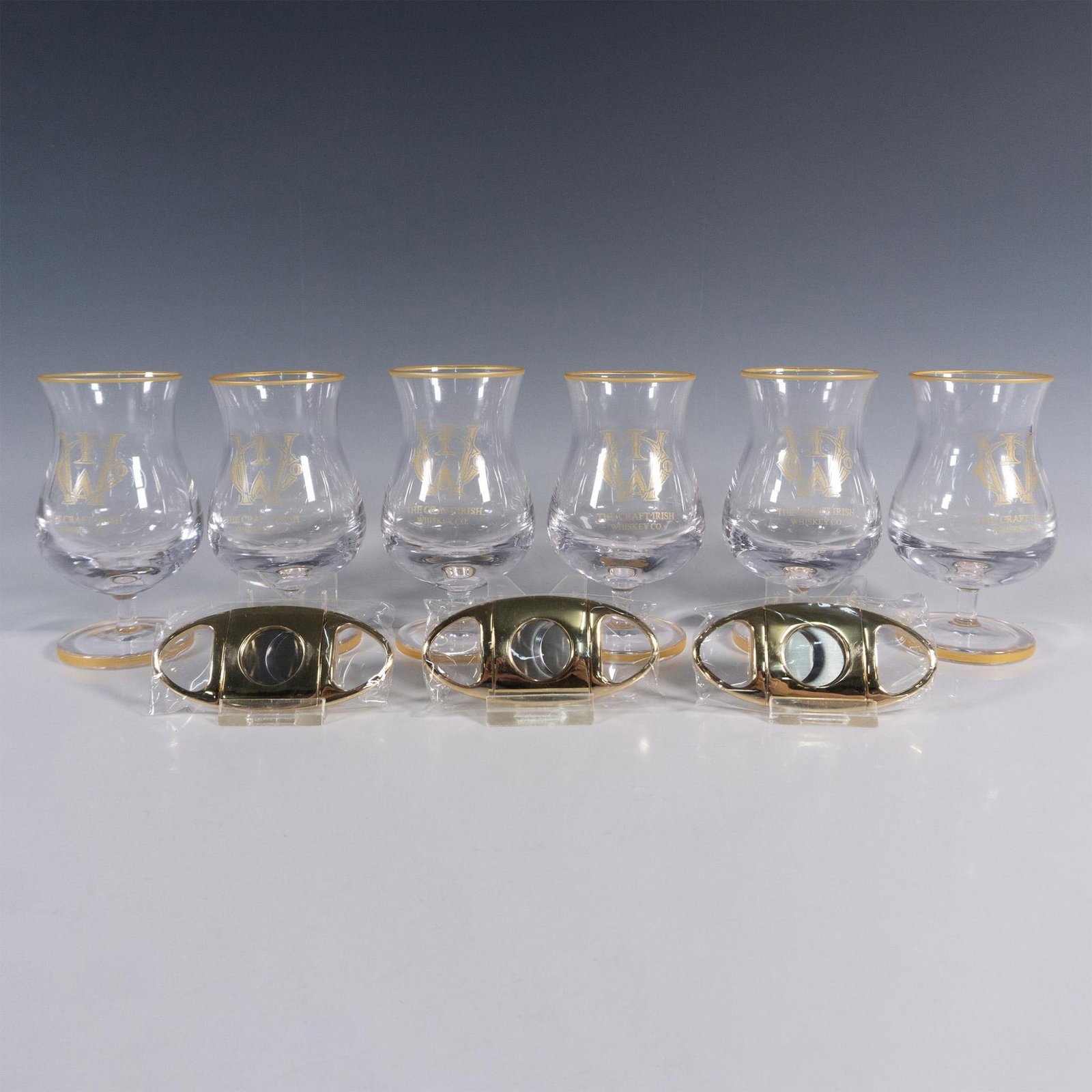 9pc The Craft Irish Whiskey Co. Finn Glass Set: This distinguished collection by The Craft Irish Whiskey Co. proudly showcases their logo and includes 6 Finn whiskey tasting glasses and 3 sleek cigar cutters, perfect for gifting at your next whiske