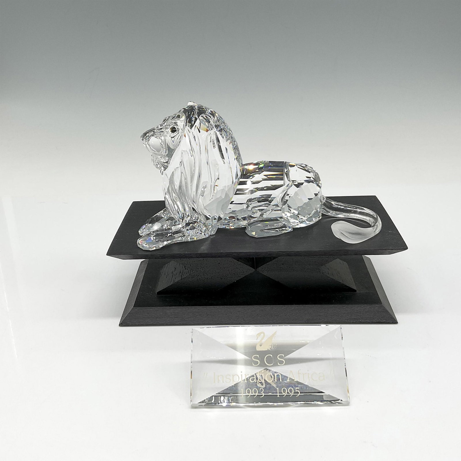 3pc Swarovski CS Figurine, 1995 Lion, Base & Plaque: Part of the Inspiration Africa trilogy. This king of the jungle was created with clear faceted crystal, smooth crystal tail with frosted tip. Includes SCS Inspiration Africa plaque 1993 - 1995. This i