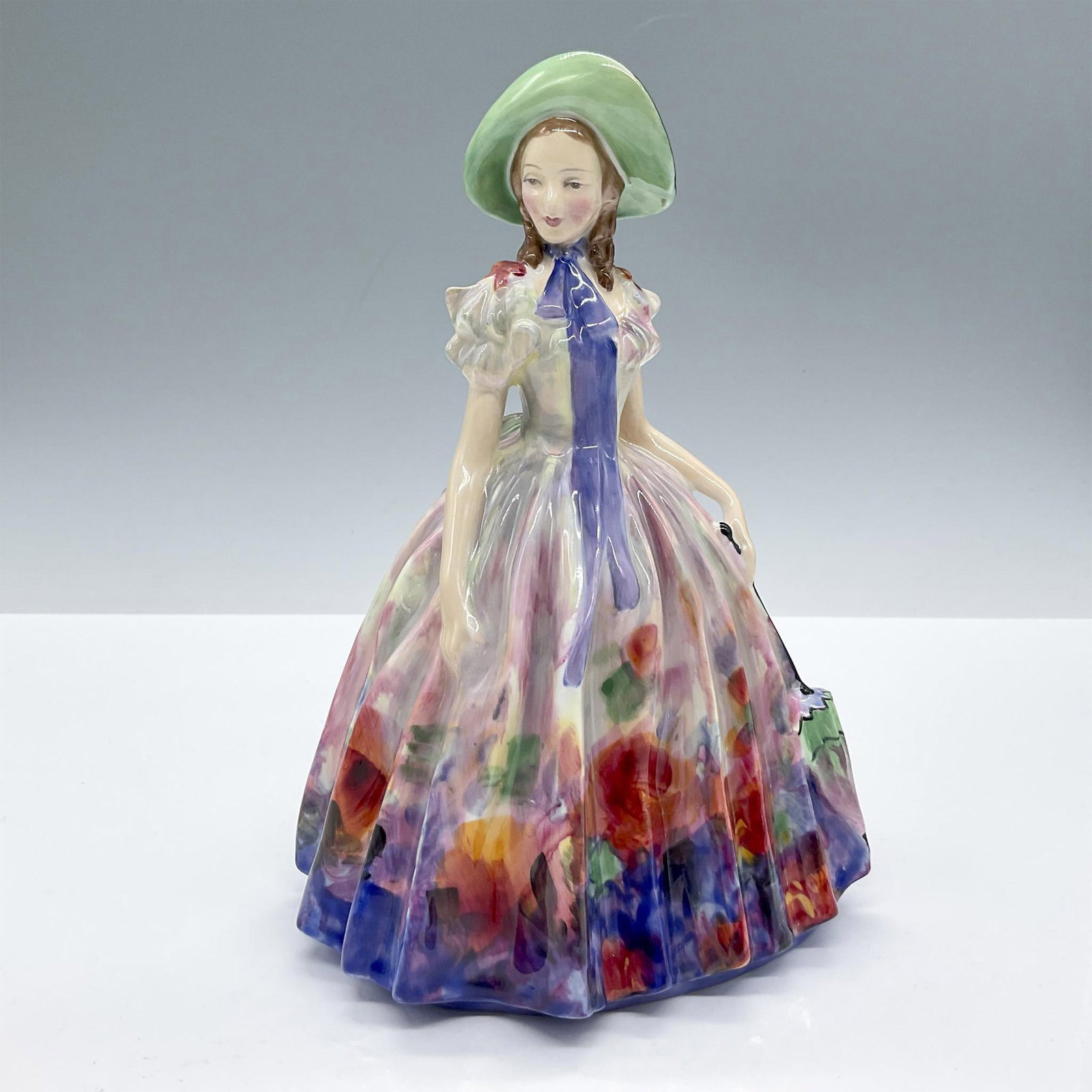 Easter Day - HN2039 - Royal Doulton Figurine: From the Royal Doulton Pretty Ladies collection. Features a girl wearing a rich multicolored dress. Royal Doulton backstamp. Artist: Leslie Harradine Issued: 1949 - 1969 Dimensions: 7.25"H Manufacture