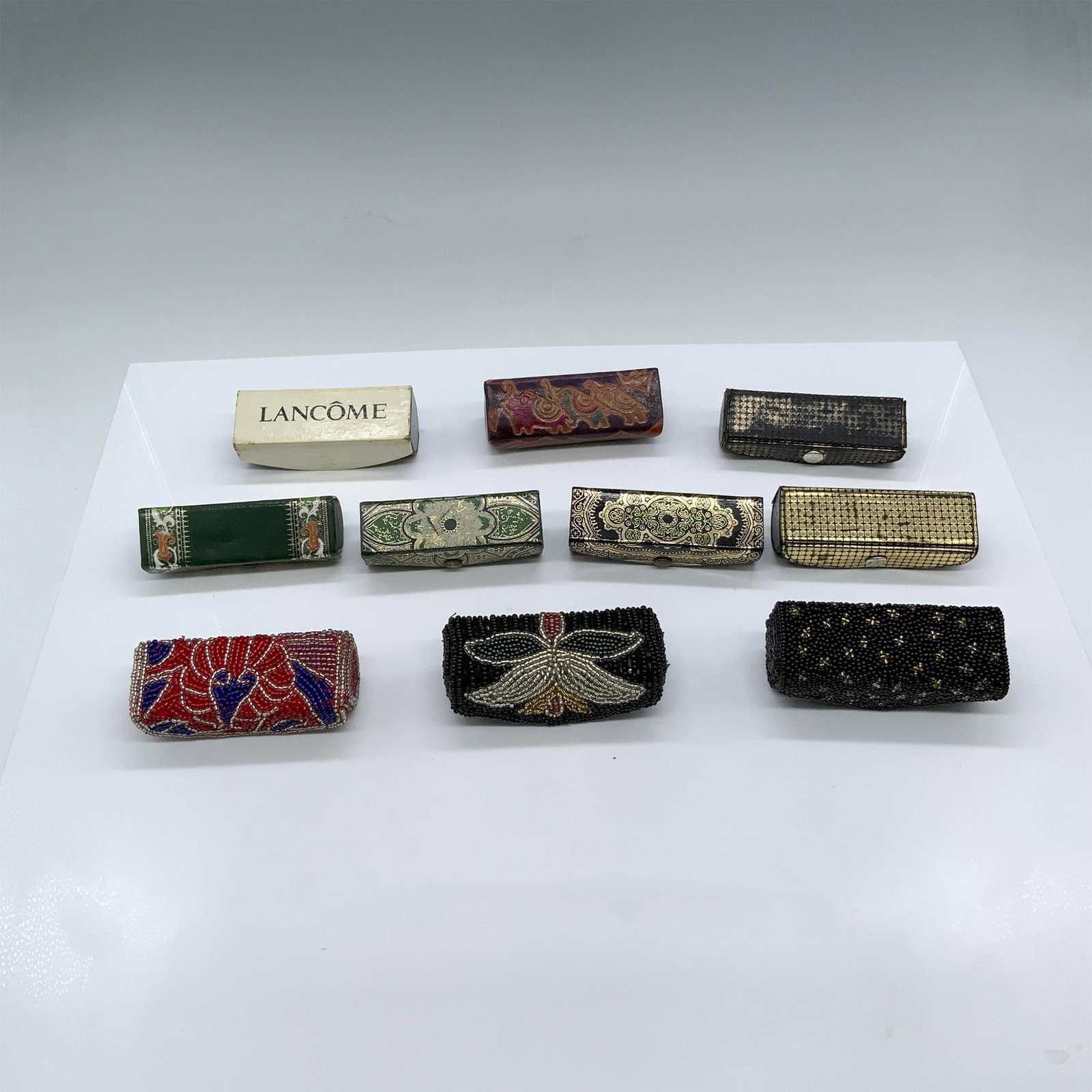 10pc Fancy Lipstick Cases: This lot includes ten beautiful lipstick cases made from various materials. Several are genuine leather. The largest measures 1.25"L x 1.25"W x 3.5"H. Dimensions: See Description