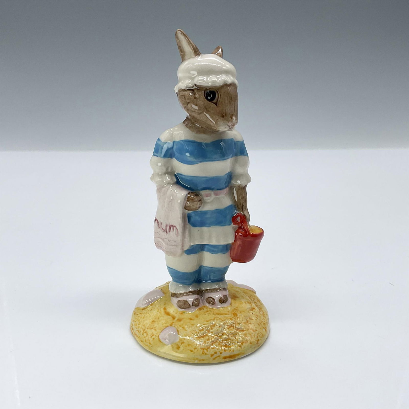 Royal Doulton Bunnykins Figurine, Mother Bunnykins DB189: This porcelain figurine depicts Mother Bunnykins in her blue and white striped bathing suit. Royal Doulton backstamp. Artist: C. Dadd Issued: 1999 Dimensions: 4"H Manufacturer: Royal Doulton Country