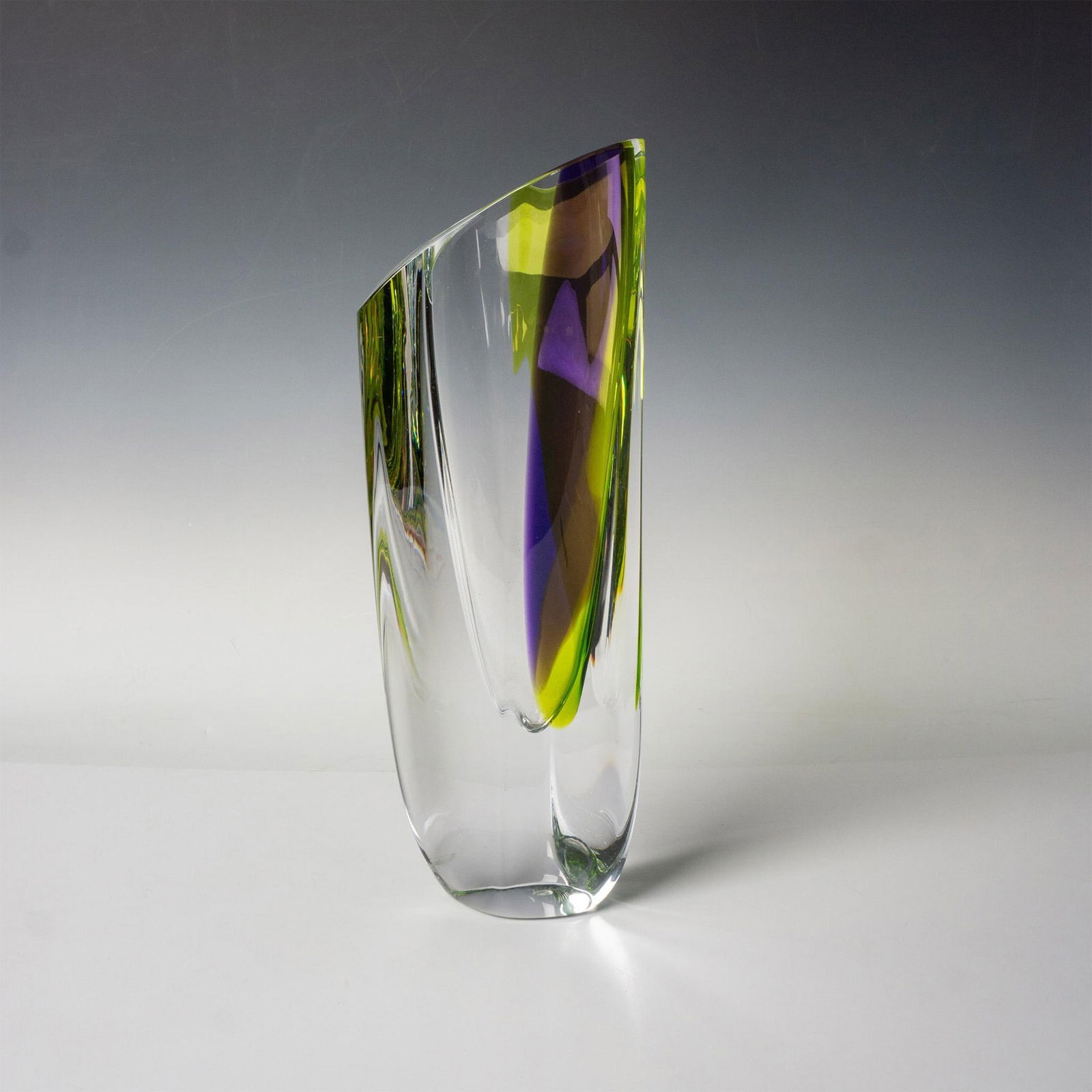 Kosta Boda by Goran Warff Vase, Saraband - Purple Green: A dramatic art glass piece that can be seen as a vase and a sculpture. Clear with sharp edges and dramatic colors of purple and green. Artist etched signature. Marked Kosta Boda. This item has its ori