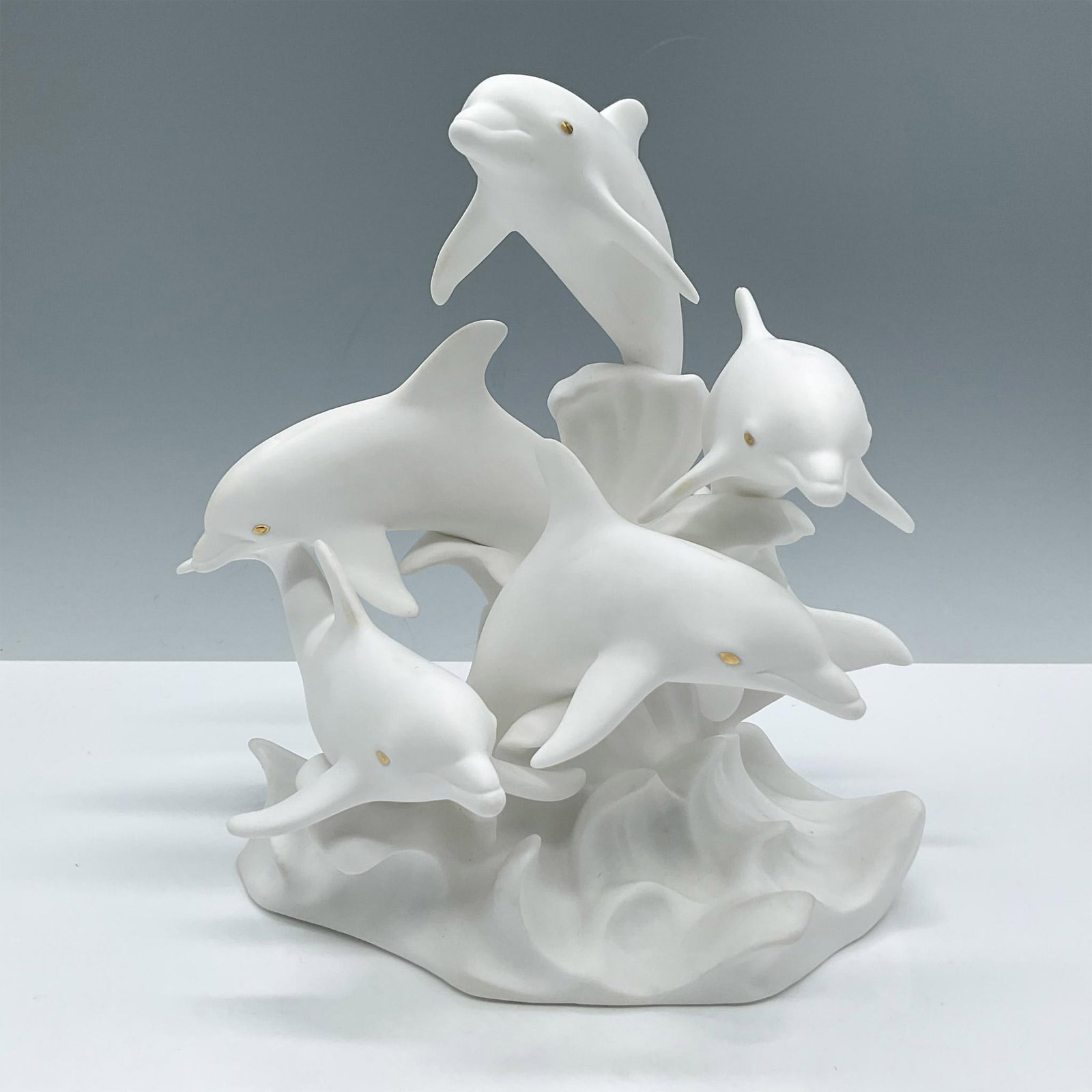 Lenox Fine Bone China Figurine, Sea Symphony: Limited edition. Modeled in white matte with gold eyes, depicts a majestic scene of a group of dolphins jumping gracefully with the waves. Lenox backstamp. Issued: 1995 Dimensions: 5.5''L x 7''W x 7.5