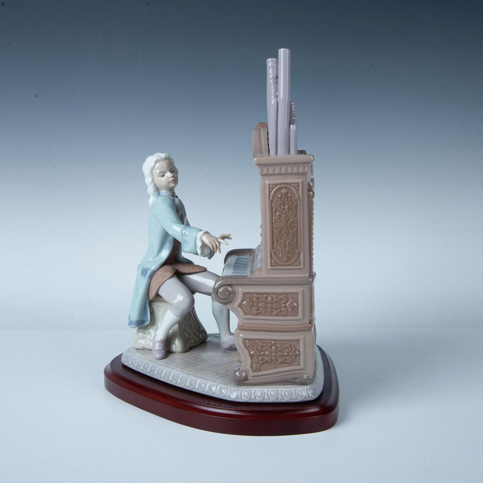 Lladro Porcelain Figurine, Young Bach 1001801 with Base: Beautiful organ with player. Includes its wooden base, and the original box. Dimensions of the base: 10''W x 8.75''L x 1''H. Dimensions of the box: 10.5''L x 17.5''W x 10.5''H. Lladro backstamp. Artis
