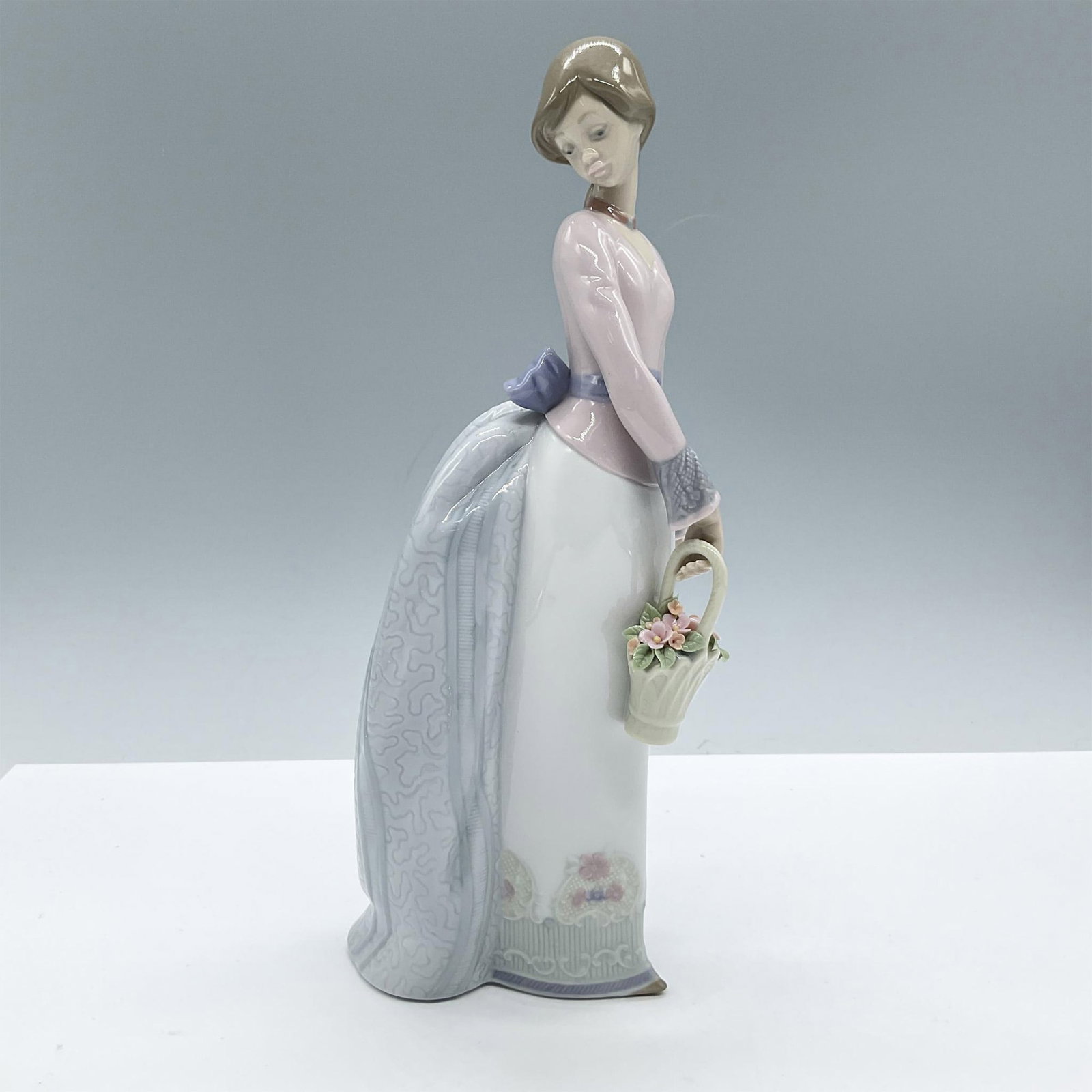 Basket Of Love 1007622 - Lladro Porcelain Figurine: Glossy finish; Lladro backstamp. Includes the original box, dimensions: 7.5''L x 12.5''W x 6''H. Artist: Jose Puche Issued: 1994 - 1994 Dimensions: 9.75"H x 4"W Manufacturer: Lladro Country of Origin: