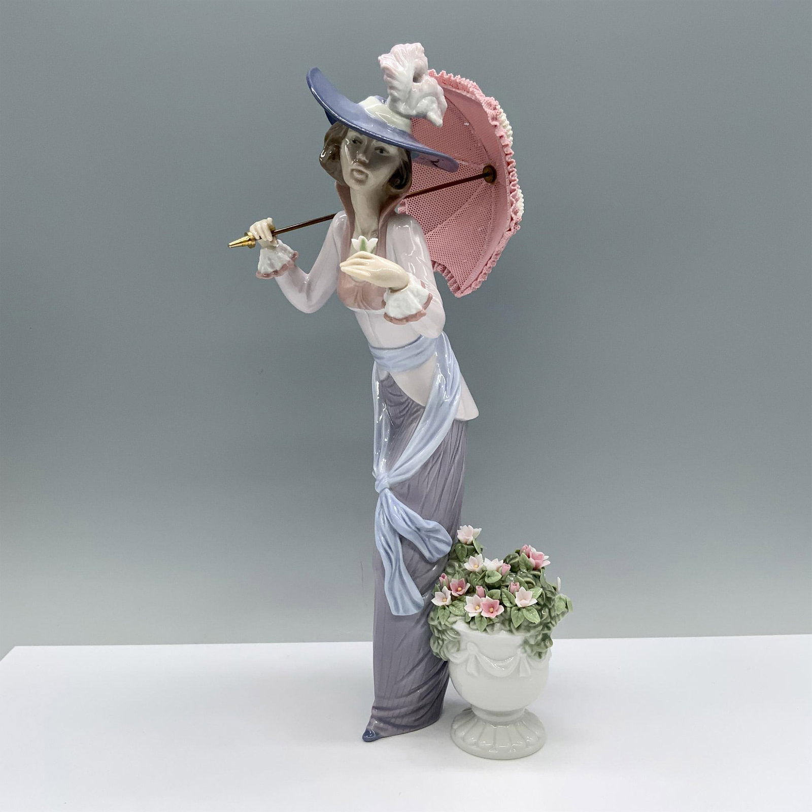 Flowers Of Paris 1006279 - Lladro Porcelain Figurine: Glossy finish; Lladro backstamp. Artist: Regino Torrijos Issued: 1996 - 1999 Dimensions: 11.75"H x 5.5"W Manufacturer: Lladro Country of Origin: Spain