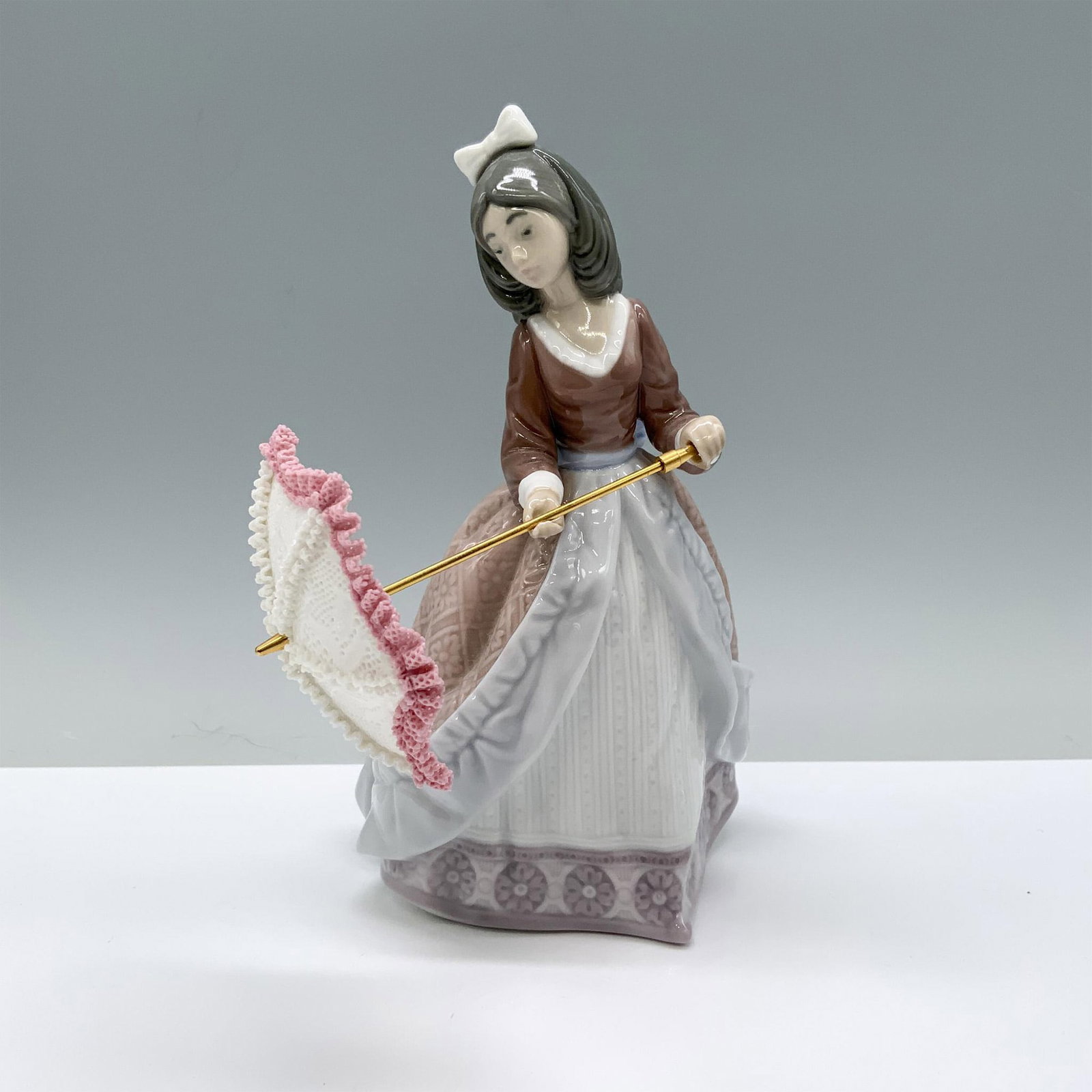 Jolie 1005210 - Lladro Porcelain Figurine: Glossy finish; Lladro backstamp. Artist: Jose Puche Issued: 1984 - 2002 Dimensions: 8.75"H x 4.25"W Manufacturer: Lladro Country of Origin: Spain