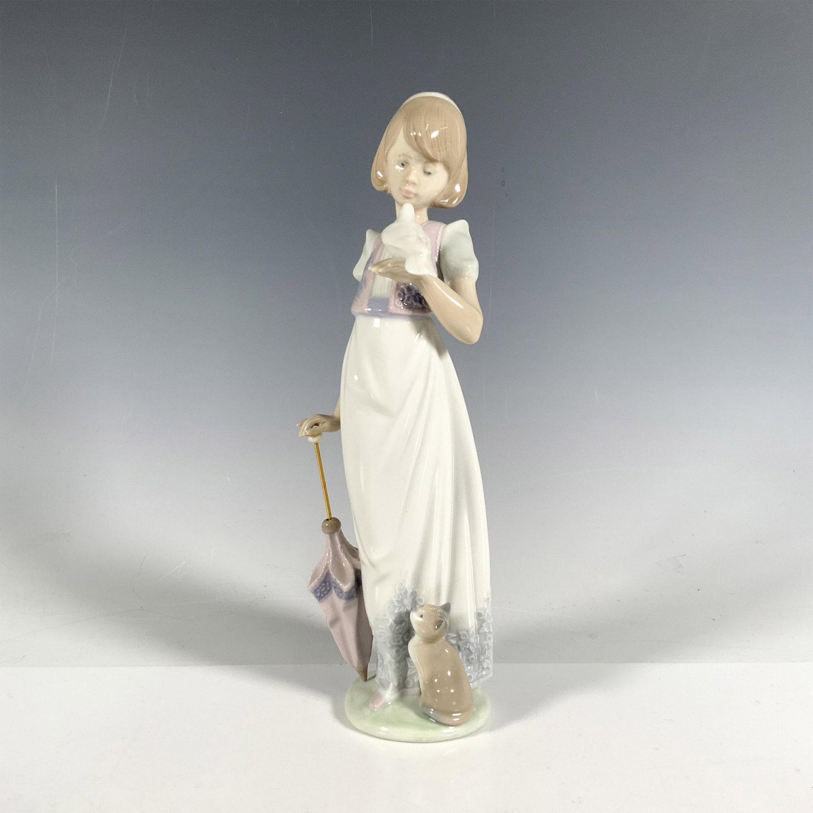 Summer Stroll 1007611 - Lladro Porcelain Figurine: Glossy finish; Lladro backstamp. Includes original box. Dimensions of the box: 10.75"L x 5.5"W x 5"H. Artist: Juan Huerta Issued: 1991 - 1991 Dimensions: 9.5"H x 3.25"W Manufacturer: Lladro Country o
