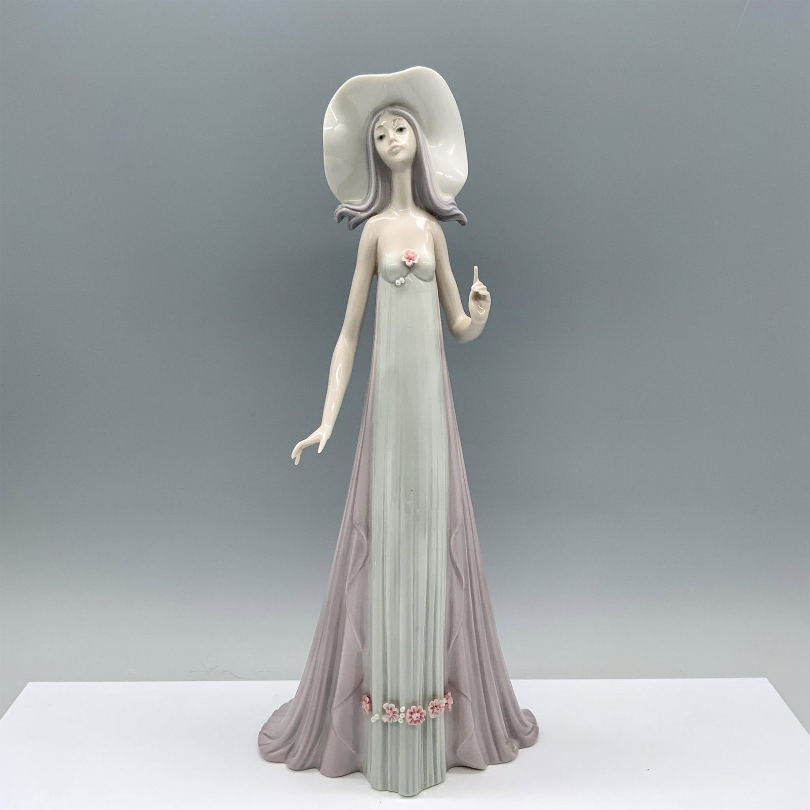 The Debutante 1001431 - Lladro Porcelain Figurine: Glossy finish; Lladro backstamp. Artist: Jose Puche Issued: 1982 - 1998 Dimensions: 13.75"H x 6.25"W Manufacturer: Lladro Country of Origin: Spain