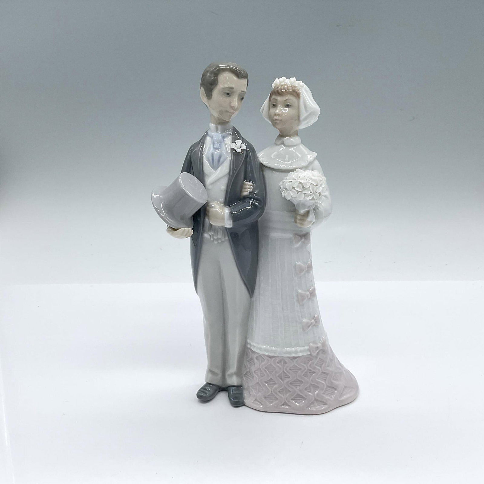 Wedding 1004808 - Lladro Porcelain Figurine: Glossy finish; Lladro backstamp. Includes original box: 11"L x 5.75"W x 5"H. Dimensions: 3''L x 4''W x 8''H