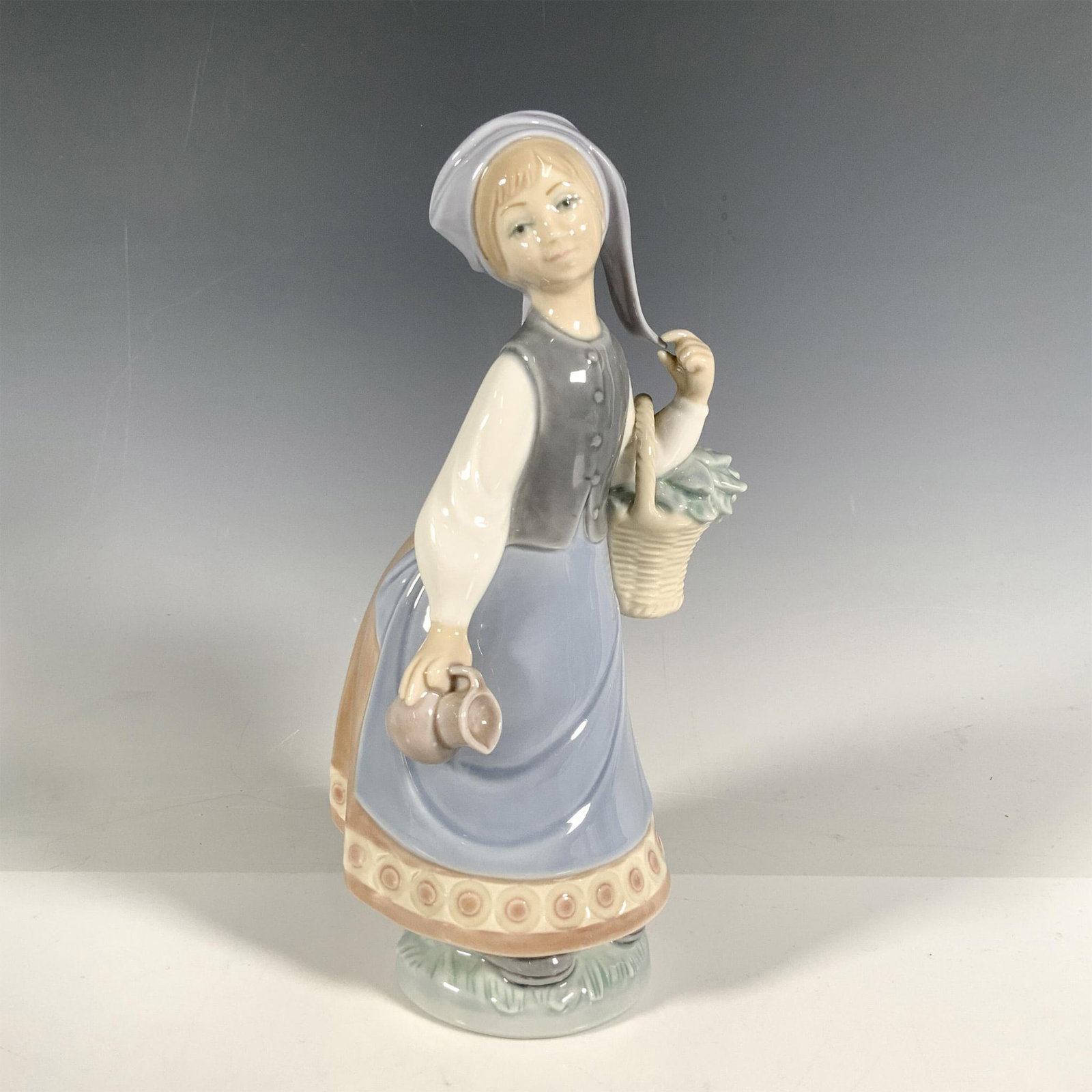 Woman W/scarf 1005024 - Lladro Porcelain Figurine: Glossy finish; Lladro backstamp. Includes original box. Dimensions of the box: 10.5"L x 5.5"W x 5"H. Artist: Julio Fernandez Issued: 1978 - 1985 Dimensions: 8.75"H Manufacturer: Lladro Country of Ori